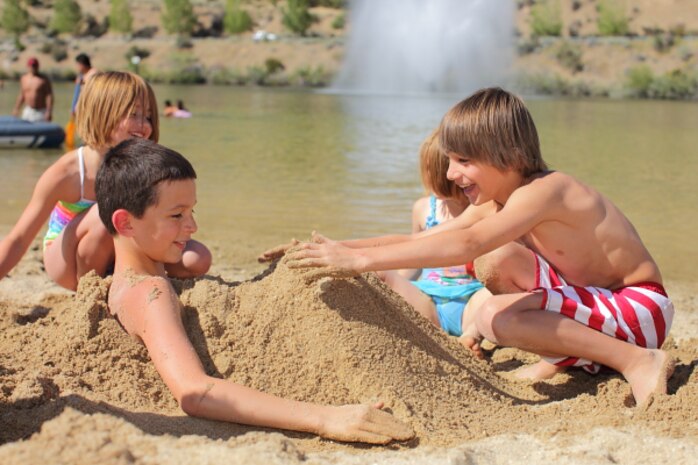 Kids enjoy the cool sand at Lucky Peak State Park’s Sandy Point Unit.