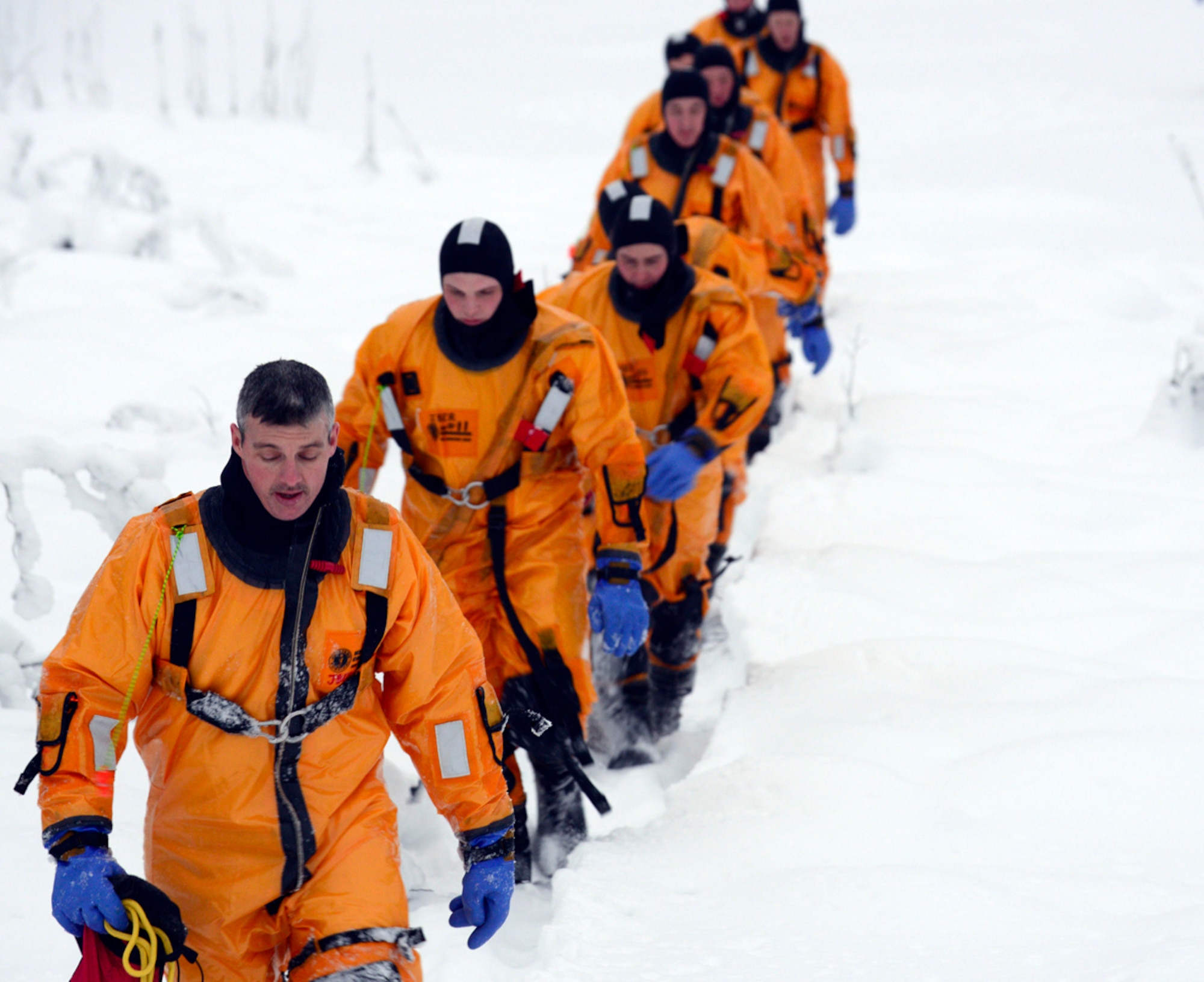 The 673d Civil Engineer Squadron firefighters walk in a single-line formation after completing the first phase of ice water rescue training at Joint Base Elmendorf-Richardson, Alaska, Jan. 13, 2014. 
