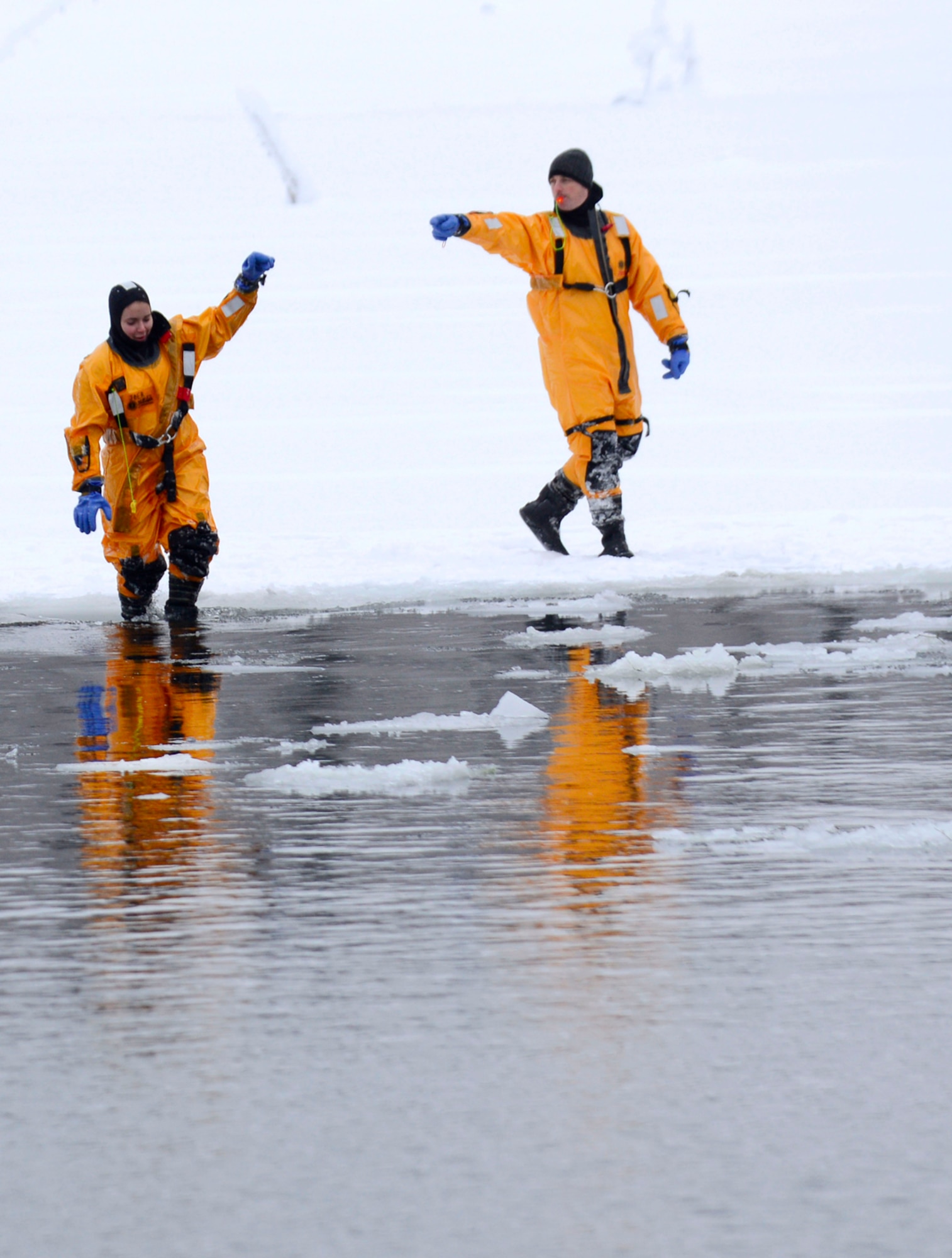 Louis Larousse, ice water rescue training instructor, signal Airman 1st Class Sarah Logodicio to jump into Upper Sixmile Lake in 14-Idegree weather during an ice water rescue training at Joint Base Elmendorf-Richardson, Alaska, Jan. 13, 2013. Larousse and Logodicio are both assigned to the 673d Civil Enginner Squadron firefighter. (U.S. Air Force photo/Staff Sgt. Sheila deVera)