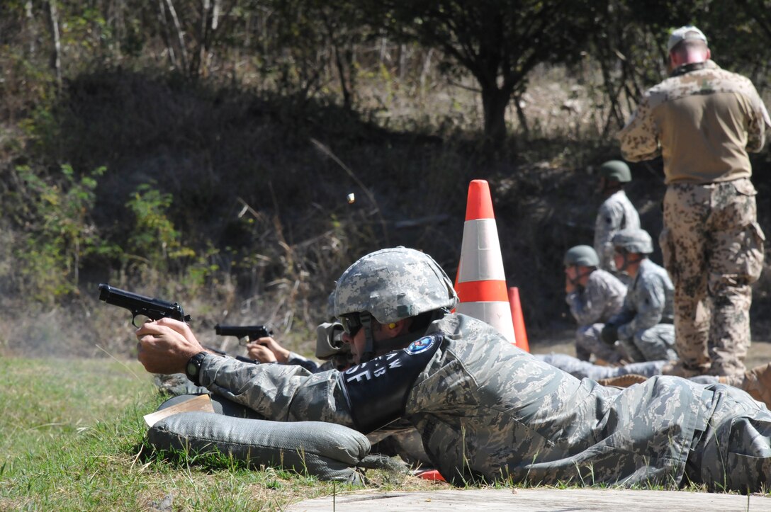 Members of Joint Task Force-Bravo fire M9 pistols at targets 25 meters away as part of the German Armed Forces Proficiency Badge Qualification test at Soto Cano Air Base, Honduras, Jan. 14, 2014.  Forty members of Joint Task Force-Bravo earned the badge over three days of testing.  (Photo by Ana Fonseca)