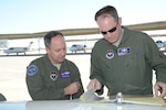 Air Force Col. Ken Frollini (left), Air Education and Training Command inspector general, and Air Force Lt. Col. Dan Rohlinger, 99th Flying Training Squadron instructor pilot, review aircraft maintenance forms on a student training mission Tuesday at Joint Base San Antonio-Randolph during the 12th Flying Training Wing's 2014 Headquarters AETC Combined Unit Inspection. (U.S. Air Force photo by Joel Martinez)