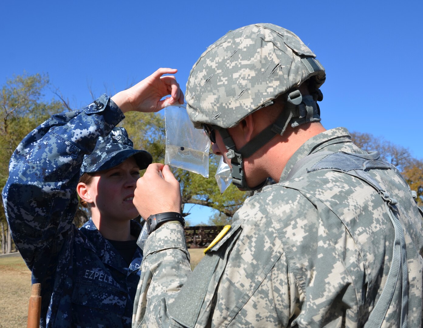 (From left) Petty Officer 2nd Class Kari Ezpeleta and Spc. Nate Sturgis
check a water sample for insect specimens.