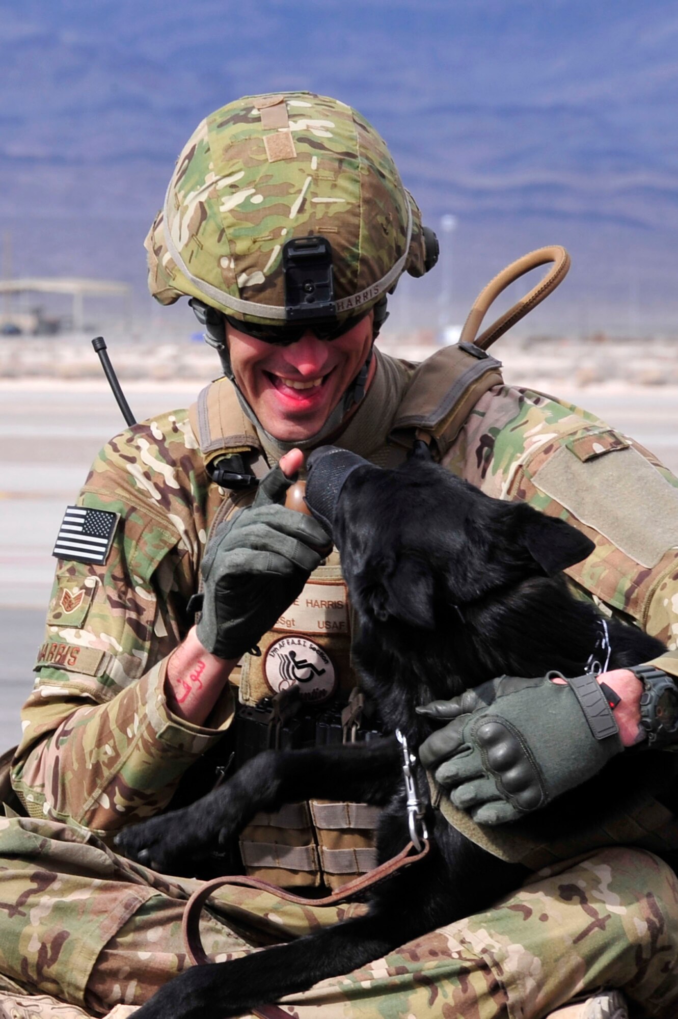 Military working dog handler Staff Sgt. Jesse Harris plays with his canine partner as they wait for a 99th Ground Combat Training Squadron exercise Feb. 6.
