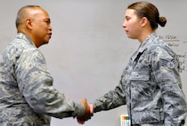 PETERSON AIR FORCE BASE, Colo. Col. Roy Agustin, Air Force Reserve Command A7 (Installations and Mission Support) deputy, recognized Air Force Reservist Senior Airman Ashlee Debuf with a coin during his visit to the 302nd Civil Engineer Squadron Jan. 11, 2013. Debuf performed seasoning training with the host unit active duty 21st CES in 2013 where she was commended on her outstanding professionalism, military bearing and work ethic by the 21st CES commander as well as several senior noncommissioned officers. She also played an integral part in the Unit Control Center stand up during the Black Forest fire, ensuring accountability of military personnel and monitoring military response. Debuf is a Civil Engineer Operations journeyman. (U.S. Air Force photo/Master Sgt. Daniel Butterfield) 