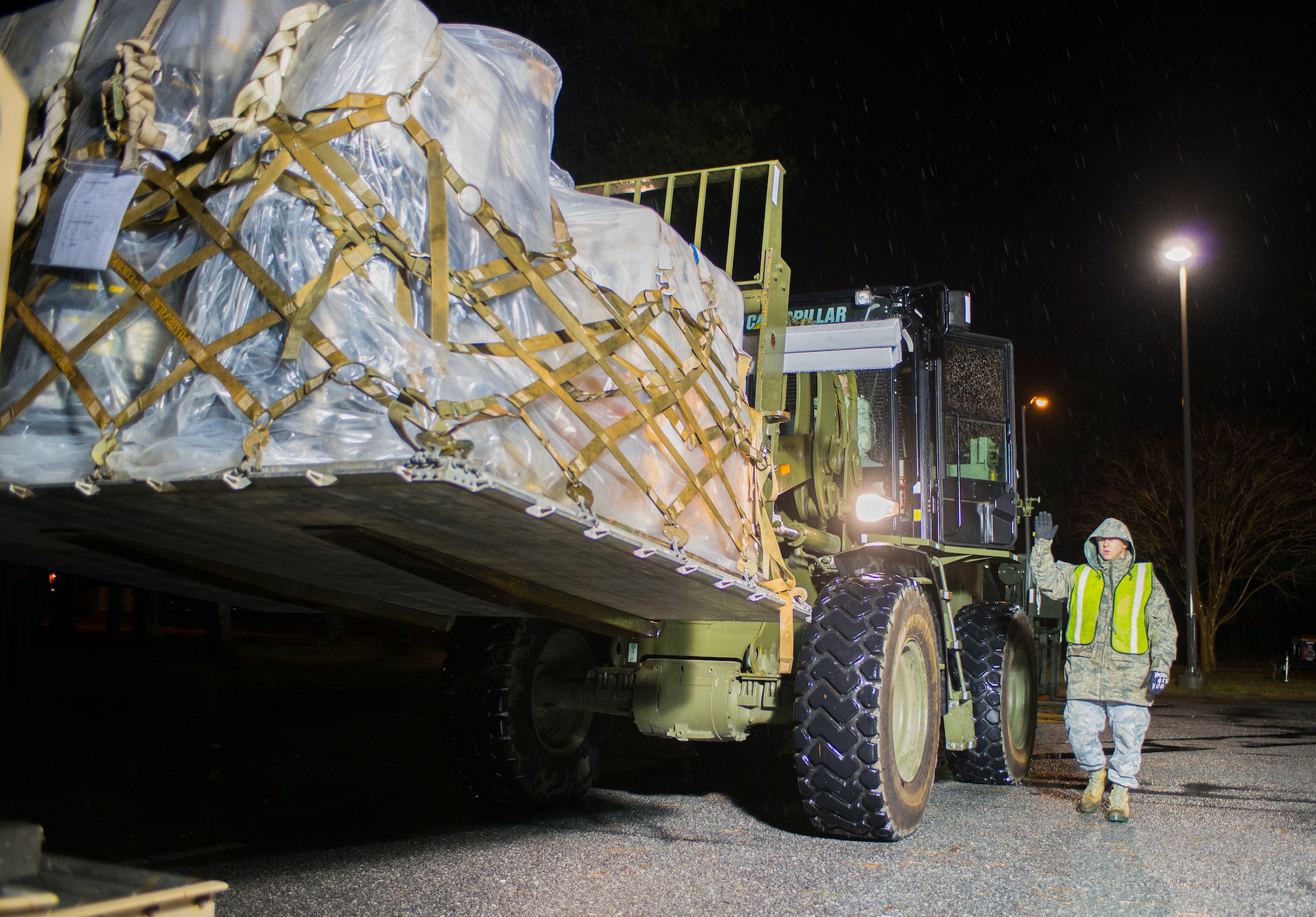 U.S. Air Force Senior Airman Steven Tepperberg, 23d Communications Squadron radar maintenance journeyman, directs a forklift operator at Moody Air Force Base, Ga., Jan. 14, 2014. Tepperberg and a team of Airmen weighed and logged each pallet as part of a wing-wide exercise. (U.S. Air Force photo by Airman 1st Class Ryan Callaghan/Released)
