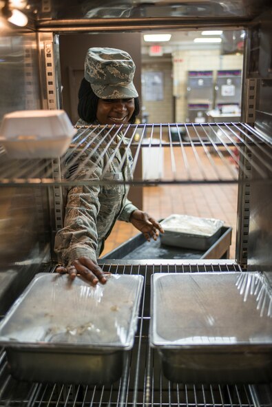 U.S. Air Force Tech. Sgt. Tiffany Buford, 23d Force Support Squadron dining facility manager, moves food into a warming oven at Moody Air Force Base, Ga., Dec. 12, 2013. Georgia Pines DFAC Airmen prepare meals in advance and keep them warm until serving time. (U.S. Air Force photo by Airman 1st Class Ryan Callaghan/Released)
