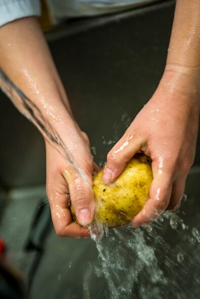 U.S. Air Force Airman 1st Class Tiffany Atkisson, 23d Force Support Squadron services apprentice, washes a potato at Moody Air Force Base, Ga., Dec. 12, 2013. The Georgia Pines Dining Facility prepares two or three main entrees with sides, food to order at the grill, a salad bar and “quick-eat” style snack foods. (U.S. Air Force photo by Airman 1st Class Ryan Callaghan/Released)
