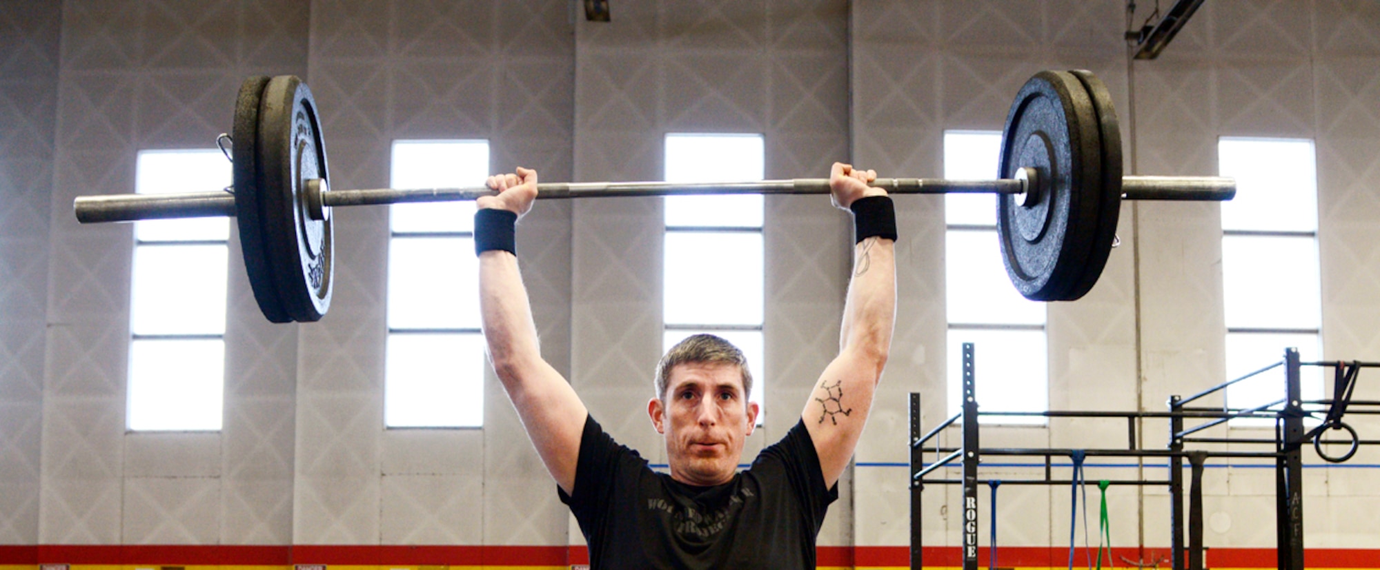 Air Force Master Sgt. Jason Phillips, 176th Air Defense Squadron air surveillance technician, performs a clean-and-jerk during an Arctic CrossFit class inside Hangar 5 at Joint Base Elmendorf-Richardson last month. Arctic CrossFit provides classes to accommodate individuals with different strength abilities and experience levels as well as coaches to help beginners walk through each exercise. (U.S. Air Force photos/Staff Sgt. Sheila deVera)
