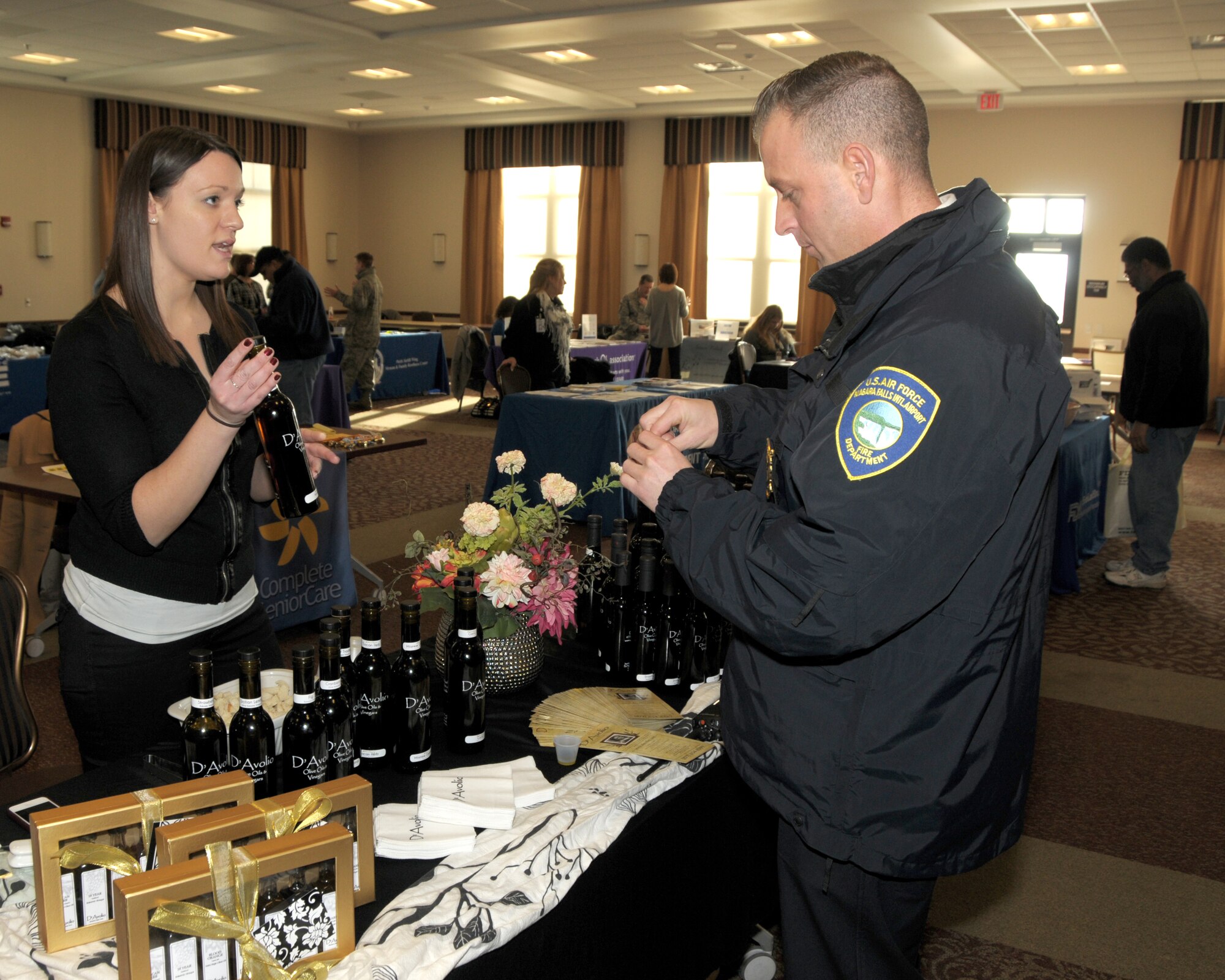 Karen Lombardi (left), a demonstrator with D'Avolio chats with Assistant Fire Chief Joe Foucha, Niagara Falls Air Reserve Station Fire Department about the different olive oils and vinegars and the health benefits it provides on January 15, 2013 at the Niagara Falls Air Reserve Station, NY. Approximately 30 vendors were on hand at the Get Fit Wellness Seminar which was held at the Niagara Heritage Center. Some of the vendors offered information on bone density screening, smoking cessation, glucose/BMI screening, animal therapy and more. (U.S. Air Force photo by Peter Borys)
