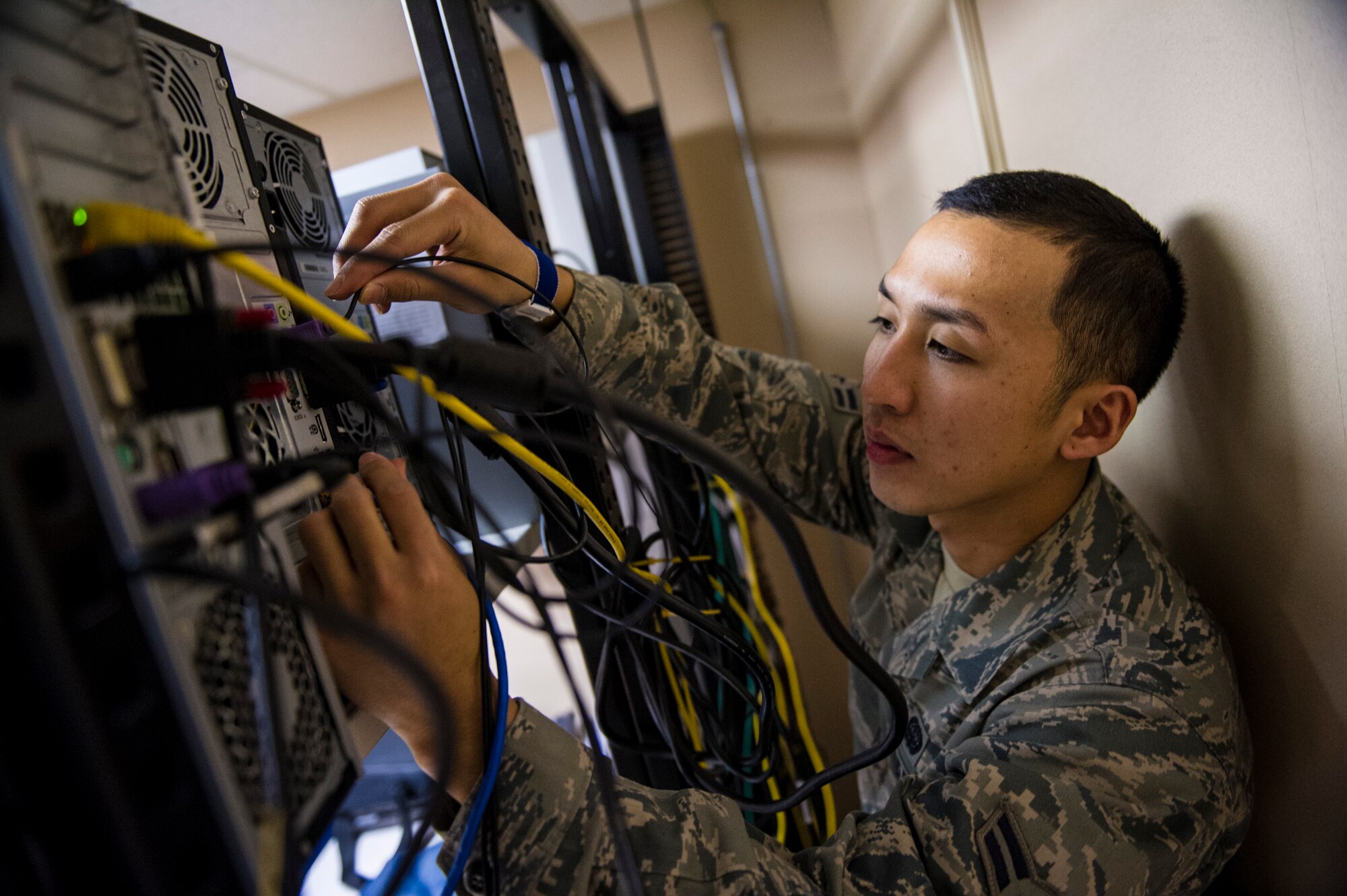 Airman 1st Class Arnel Nadal, 354th Communications Squadron, network control center client systems apprentice, adjusts wires on an information system Jan. 14, 2014 Eielson Air Force Base, Alaska. Cyber Icemen recently completed the required Air Force information systems Certification and Accreditation program for the base, ensuring continued network access across all base agencies. (U.S. Air Force photo by Senior Airman Joshua Turner)