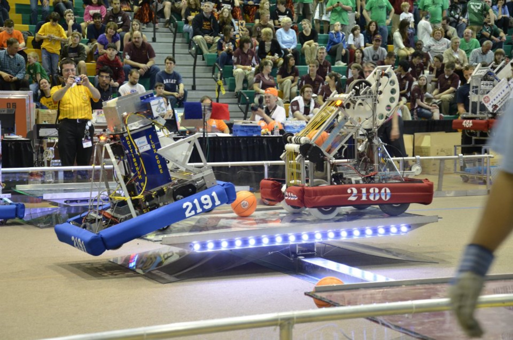 “Zero Gravity” Robotics Team robot #2180, on the right, competes in the Mid-Atlantic Regional FIRST robotics competition held at Temple University in Philadelphia, PA.  The team advanced to compete in the national championships held in St. Louis, MO.(U.S. Navy photo by Thomas Worsdale/Released)