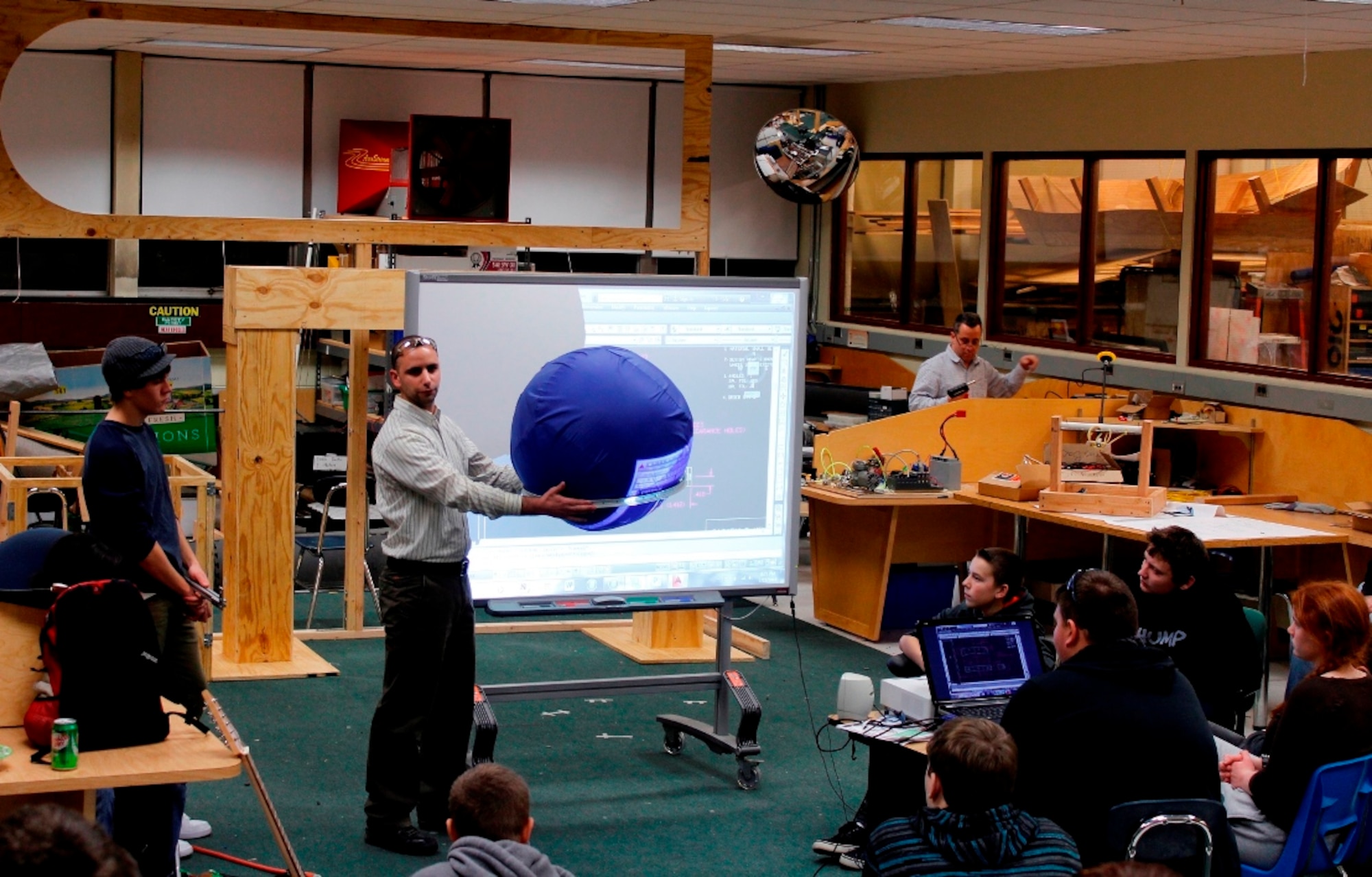 Matthew DeFelice, NAWCAD Lakehurst mechanical engineer discusses design details with his “Zero Gravity” Robotics Team members at Hamilton High School East in Mercer County, N.J. (U.S. Navy photo by Thomas Worsdale/Released)