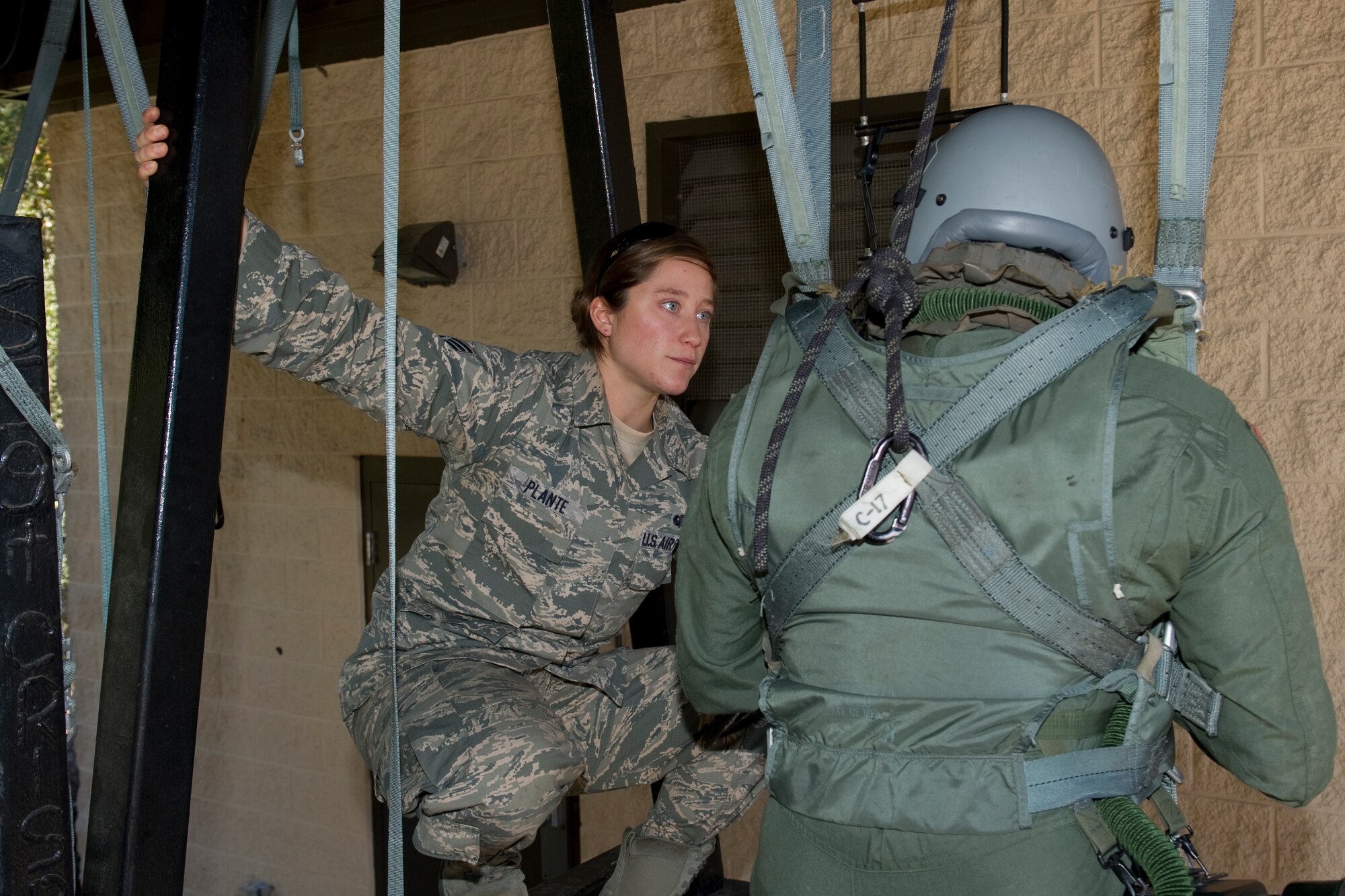 Senior Airman Charlene Plante, 1st Special Operations Support Squadron survival, evasion, resistance and escape instructor, advises an aircrew member on the proper way to escape a parachute during a SERE refresher course at Hurlburt Field, Fla., Jan. 14, 2014. Plante is one of about a dozen females who have successfully completed the SERE instructor course. (U.S. Air Force photo/Senior Airman Naomi Griego)