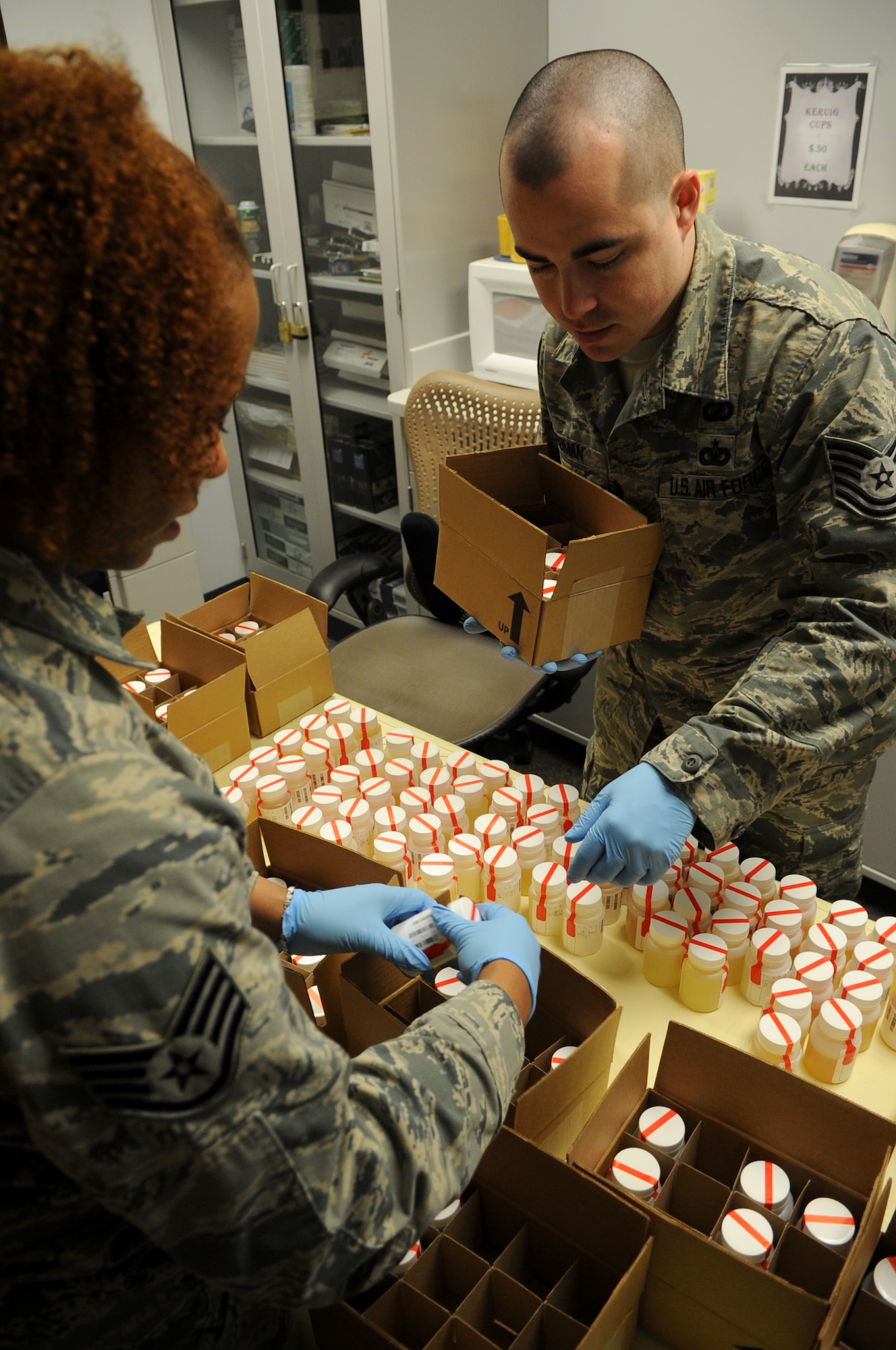 Staff Sgt. Brittani Newhouse, 19th Medical Group Drug Demand Reduction Program noncommissioned officer in charge, and Tech. Sgt. Juan Roman, 19th MDG Drug Demand Reduction Program administrative manager, separate specimens into boxes for drug testing Jan. 7, 2014, at Little Rock Air Force Base, Ark. The DDR office test approximately 500 service members and civilians per month.  (U.S. Air Force photo by Staff Sgt. Caleb Pierce)