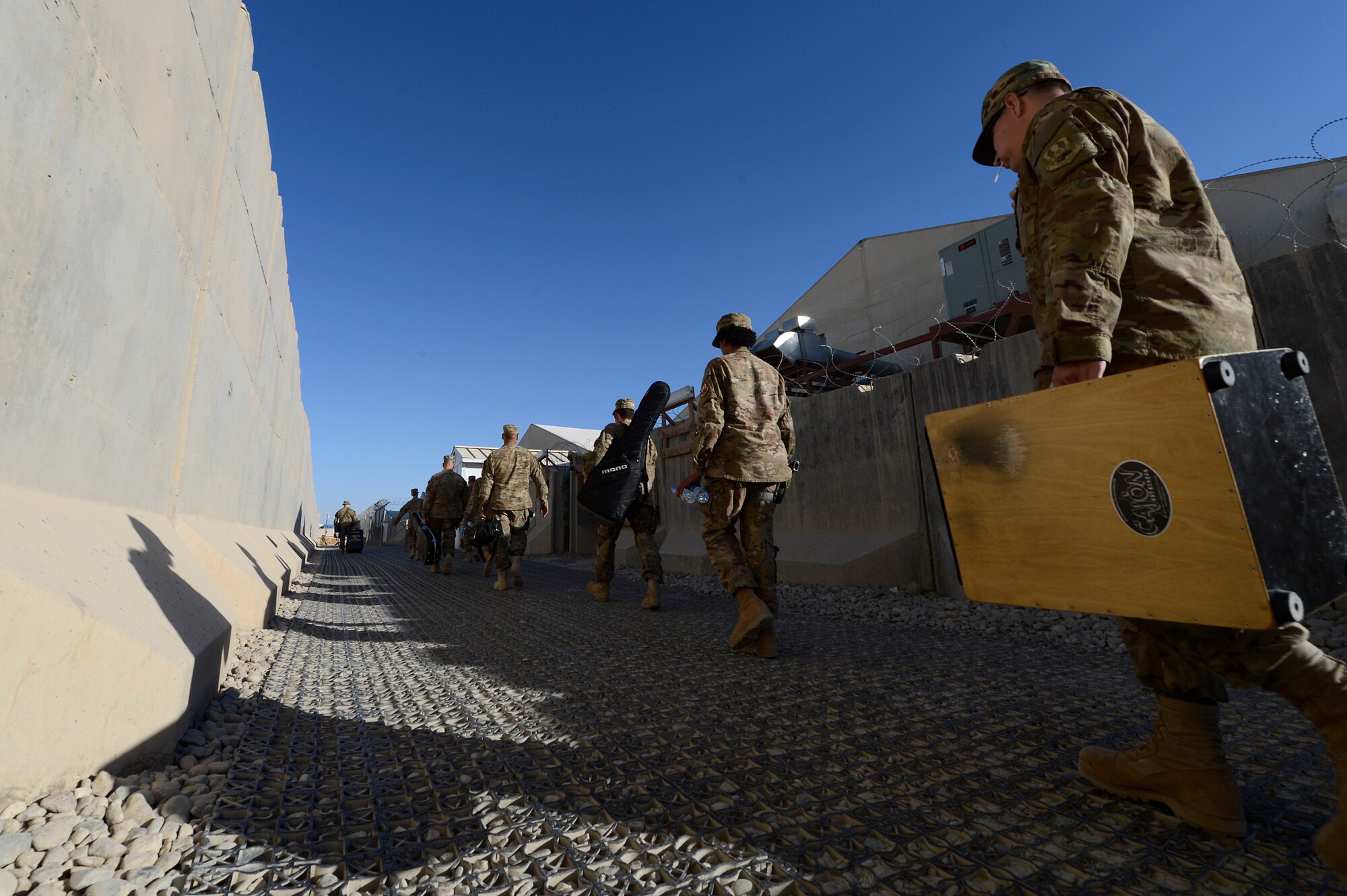 The U.S. Air Force Central Command band carries their instruments while walking to another performance location Dec. 17, 2013, at Camp Leatherneck, Afghanistan. The AFCENT band performed at various locations around Camp Leatherneck during their 15 day tour of Afghanistan. (U.S. Air Force photo by Tech. Sgt. Jason Robertson/released)