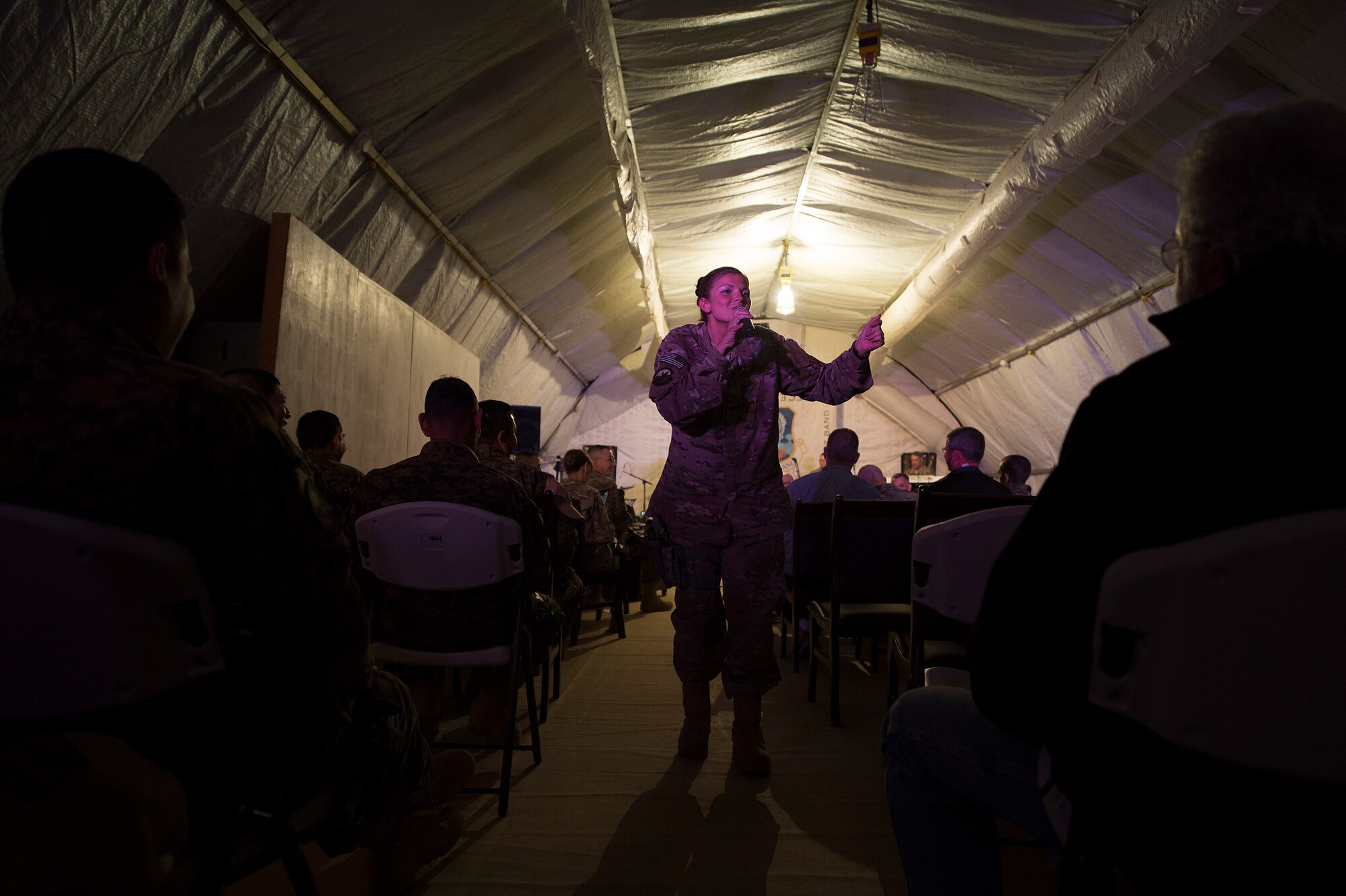 U.S. Air Force Staff. Sgt. Kelly Perry, Air Force Central Command band vocalist, entertains a coalition crowd of U.S., Italian and Afghan service members during a performance Dec. 14, 2013 at Shindand Airfield, Afghanistan. Shindand was the first stop on the bands tour of Afghanistan. Perry, a Crestwood, Ky., native, is deployed from the Air Force Band of Flight, Wright Patterson, Air Force Base, Ohio. (U.S. Air Force photo by Tech. Sgt. Jason Robertson/released)