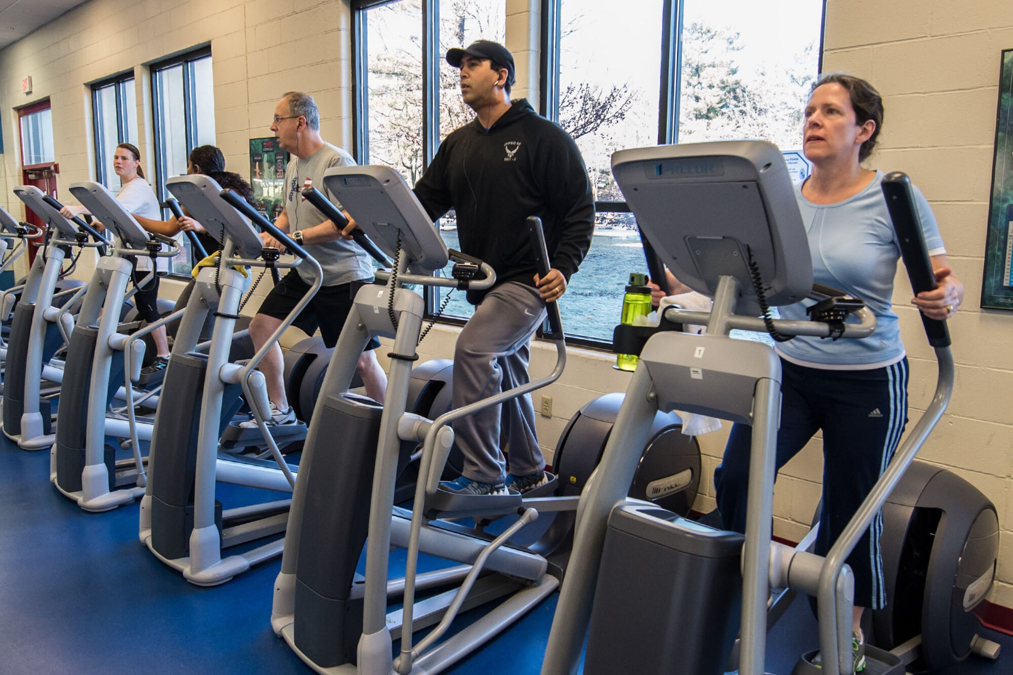 HANSCOM AIR FORCE BASE, Mass. -- (From left to right) Jennifer Decker, Noelia Velazquez, Charlie Boyajian, Kevin Burrell, Beth Roussel work out on an elliptical machine for a healthier lifestyle at the Hanscom Fitness and Sports Center Jan. 15. The Fitness Center has organized a New Year’s Resolution Challenge that runs now through March 31. The male and female with the highest total points during the challenge wins. For further information, contact the Fitness Center. (U.S. Air Force photo by Rick Berry)