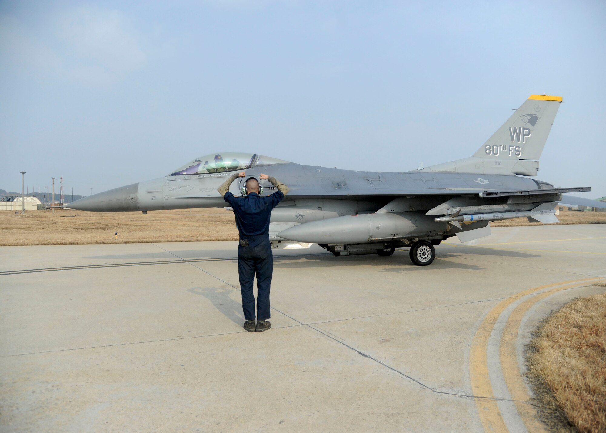 Senior Airman Nathan Faletti, 8th Aircraft Maintenance Squadron crew chief, and 8th Operations Support Squadron chief of combat training, Capt. Philip Jackson, gives the “crush ‘em” sign before take-off during exercise Buddy Wing 14-1 at Kunsan Air Base, Republic of Korea, Jan. 16, 2014. Buddy Wing is a combined training exercise between United States Air Force and Republic of Korea air force pilots to improve communication and combat capabilities to further strengthen the Peninsula’s Combined Air Power team. (U.S. Air Force photo by Staff Sgt. Jessica Haas/Released)
