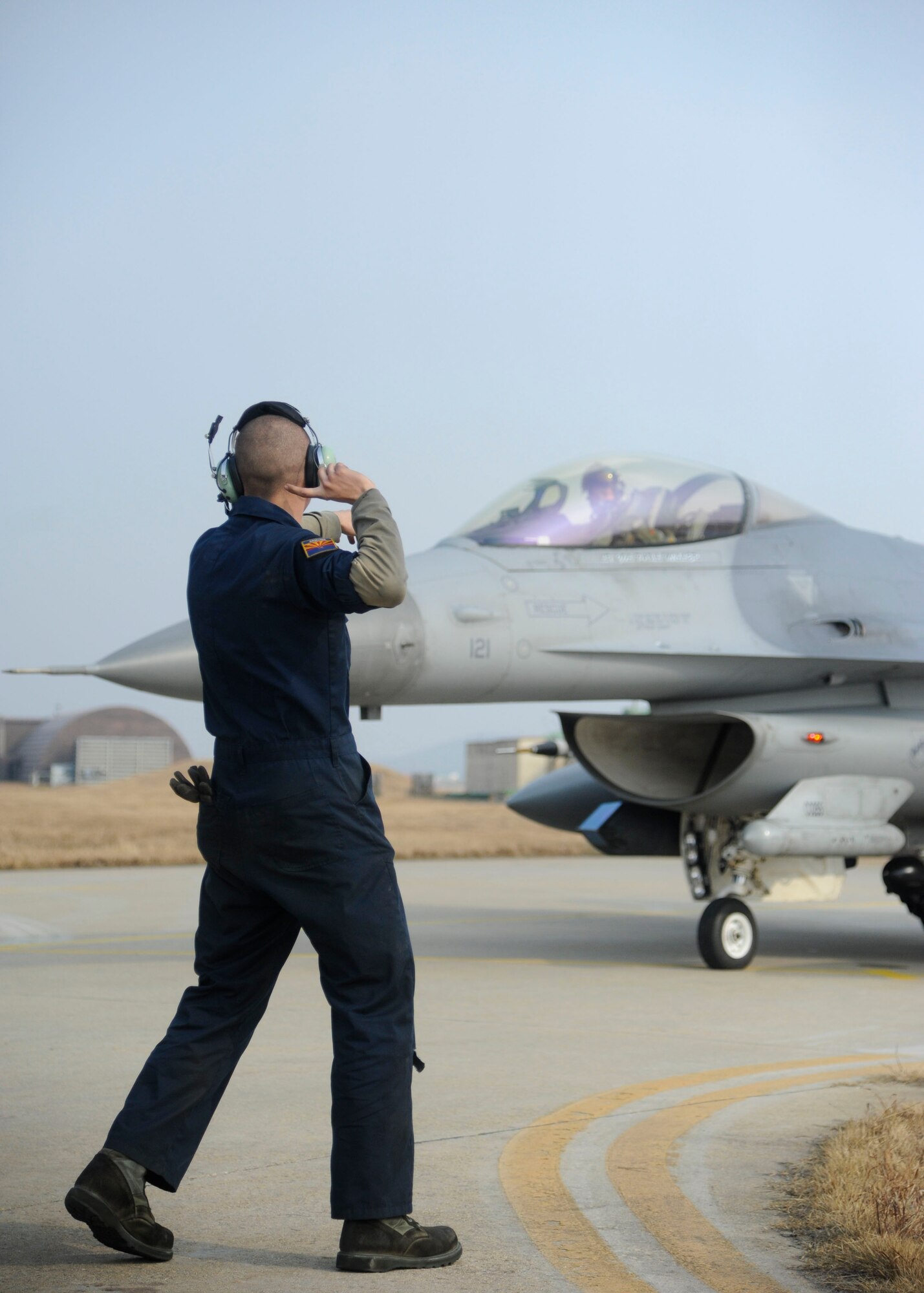 Senior Airman Nathan Faletti, 8th Aircraft Maintenance Squadron crew chief, directs 8th Operations Support Squadron chief of combat training, Capt. Philip Jackson, during exercise Buddy Wing 14-1 at Kunsan Air Base, Republic of Korea, Jan. 16, 2014. Buddy Wing is a combined training exercise between United States Air Force and Republic of Korea air force pilots to improve communication and combat capabilities to further strengthen the Peninsula’s Combined Air Power team. (U.S. Air Force photo by Staff Sgt. Jessica Haas/Released)