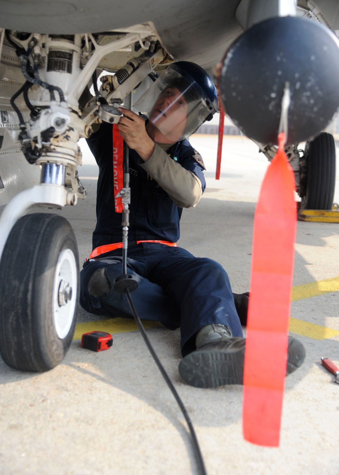 Senior Airman Nathan Faletti, 8th Aircraft Maintenance Squadron crew chief, pumps air into the shock struck system of a Fighting Falcon F-16 during exercise Buddy Wing 14-1 at Kunsan Air Base, Republic of Korea, Jan. 16, 2014. Buddy Wing is a combined training exercise between United States Air Force and Republic of Korea air force pilots to improve communication and combat capabilities to further strengthen the Peninsula’s Combined Air Power team. (U.S. Air Force photo by Staff Sgt. Jessica Haas/Released)