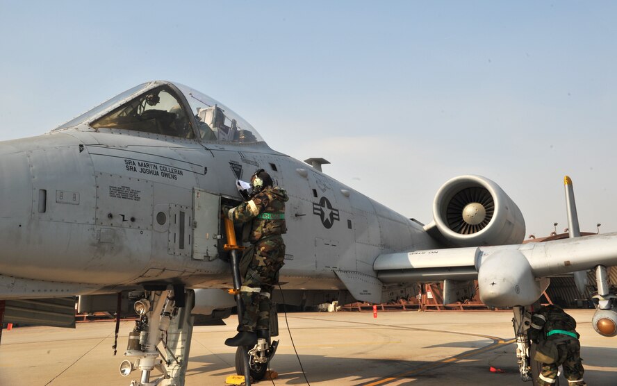 Senior Airman Alexandria Ketterhagen, 51st Aircraft Maintenance Squadron crew chief, clears a path free of mock chemical, biological, radiological or nuclear contaminants during a training scenario as part of Operational Readiness Exercise Beverly Midnight 14-01 at Osan Air Base, Republic of Korea, Jan. 15, 2014. The drill required Airmen from the 51st AMXS to treat the aircraft as if it had been contaminated in a CBRN environment. (U.S. Air Force photo/Airman 1st Class Ashley J. Thum)