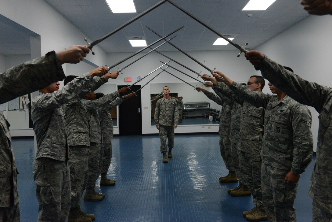 Tech. Sgt. Anthony Miller, Blue Knight Honor Guard lead trainer (center back), inspects the Andersen Blue Knights Honor Guard team as they form a sword cordon Jan. 8, 2014, on Andersen Air Force Base, Guam. The honor guard’s mission is to maintain and employ a ceremonial capability to represent the Air Force at public and official ceremonies. (U.S. Air Force photo by Airman 1st Class Emily A. Bradley/Released)