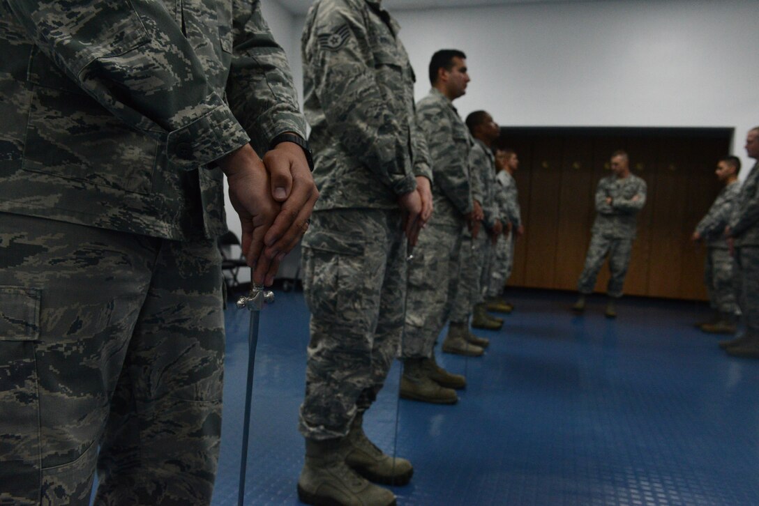 Tech. Sgt. Anthony Miller, Blue Knight Honor Guard lead trainer (center back), inspects the Andersen Blue Knights Honor Guard team as they stand at the position of ceremonial at ease Jan. 8, 2014, on Andersen Air Force Base, Guam. The honor guard’s mission is to maintain and employ a ceremonial capability to represent the Air Force at public and official ceremonies. (U.S. Air Force photo by Airman 1st Class Emily A. Bradley/Released)