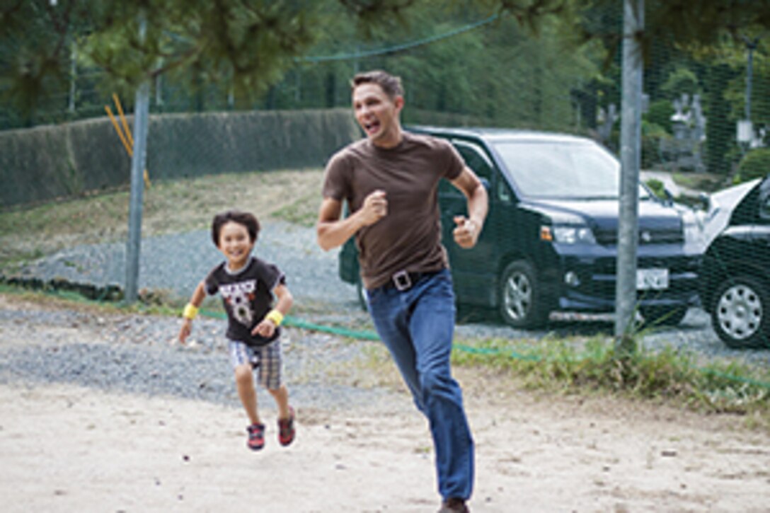 Cpl. Skyler D. Kirby, a communication navigation radar technician with Marine Tactical Electronic Warfare Squadron 2, plays tag with a child from a Yamaguchi city children’s home during a Single Marine Program trip, Oct. 19, 2013. Oana Ivanoff, SMP Marine Lounge manager, said she reached out to several other children’s homes in the hopes of finding some that have never received interaction from station residents.