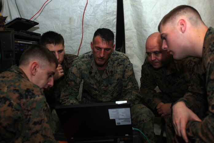 Marines with the 31st Marine Expeditionary Unit’s command element gather around a computer to test a data system during a communication exercise here, Jan. 15. The Marines built a field-based command and control center for satellite and radio communication as part of their pre-deployment exercise. The 31st MEU is the Marine Corps’ force in readiness in the Asia-Pacific region and is the only continuously forward-deployed MEU. 