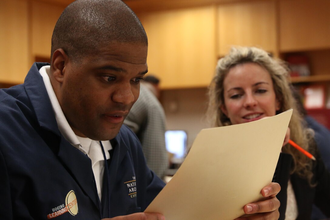 Gunnery Sgt. Douglas Bowman, the data chief at the Marine Corps Communications School, and Captain Hannah Cohen a communications officer at the Marine Corps Communications School, look closely at a document to determine where in the constitution it derives it's power at the National Archives in Washington D.C. on Jan. 16, 2014. The exercise was a part of a class offered at the archives to help people discover the day-to-day uses of the constitution. (Marine Corps photo by Lance Cpl. Cameron Storm)