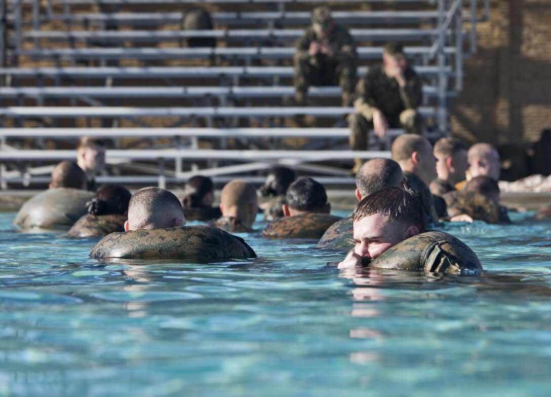 Marines with 7th Engineer Support Battalion, 1st Marine Logistics Group, blow air into their blouses to use them as flotation devices during their annual swim qualification aboard Camp Pendleton, Calif., Jan. 14, 2013. During training, Marines wore camouflage utilities while executing multiple tasks, including a 25-meter swim, jumping off a 25-foot tower, treading water for five minutes, and stripping off a combat load while sub-surfaced.
