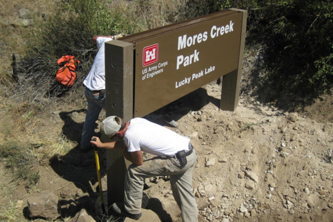 Lucky Peak Lake employees install an identification sign for Mores Creek Park.