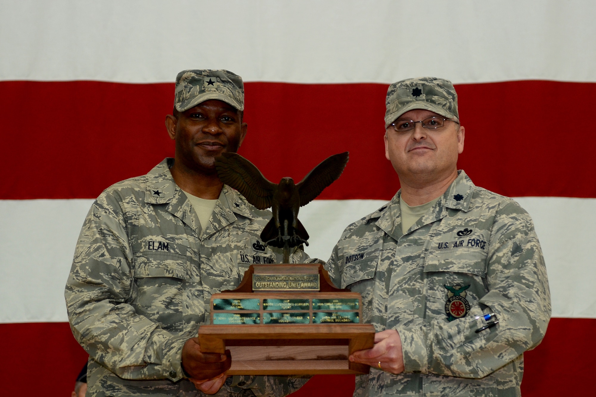 U.S. Air Force Brig. Gen. Calvin Elam, Assistant Adjutant General for Air for the South Carolina Air National Guard, presents Lt. Col. Timothy Dotson, the 169th Civil Engineer Squadron commander, with the trophy for being named the 2013 Unit of the Year, during a mass formation in the main hangar, Jan. 12, 2014.  (U.S. Air National Guard photo by Tech. Sgt. Caycee Watson/Release)