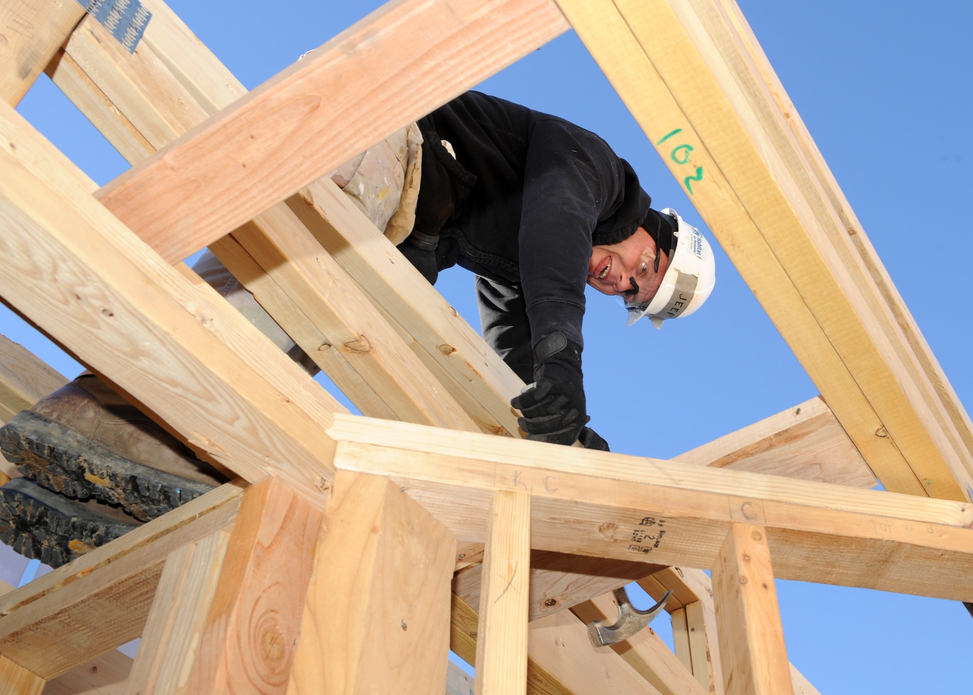 Senior Airman Daniel McElhattan, 460th Space Communication Squadron client systems technician, hammers a nail at the Habitat for Humanity build  Jan. 10, 2014, in Aurora, Colo. HFH works with 1,500 partners in the U.S. and more than 70 organizations around the world to provide safe and affordable places for families in need. (U.S. Air Force photo by Senior Airman Marcy Copeland/Released)