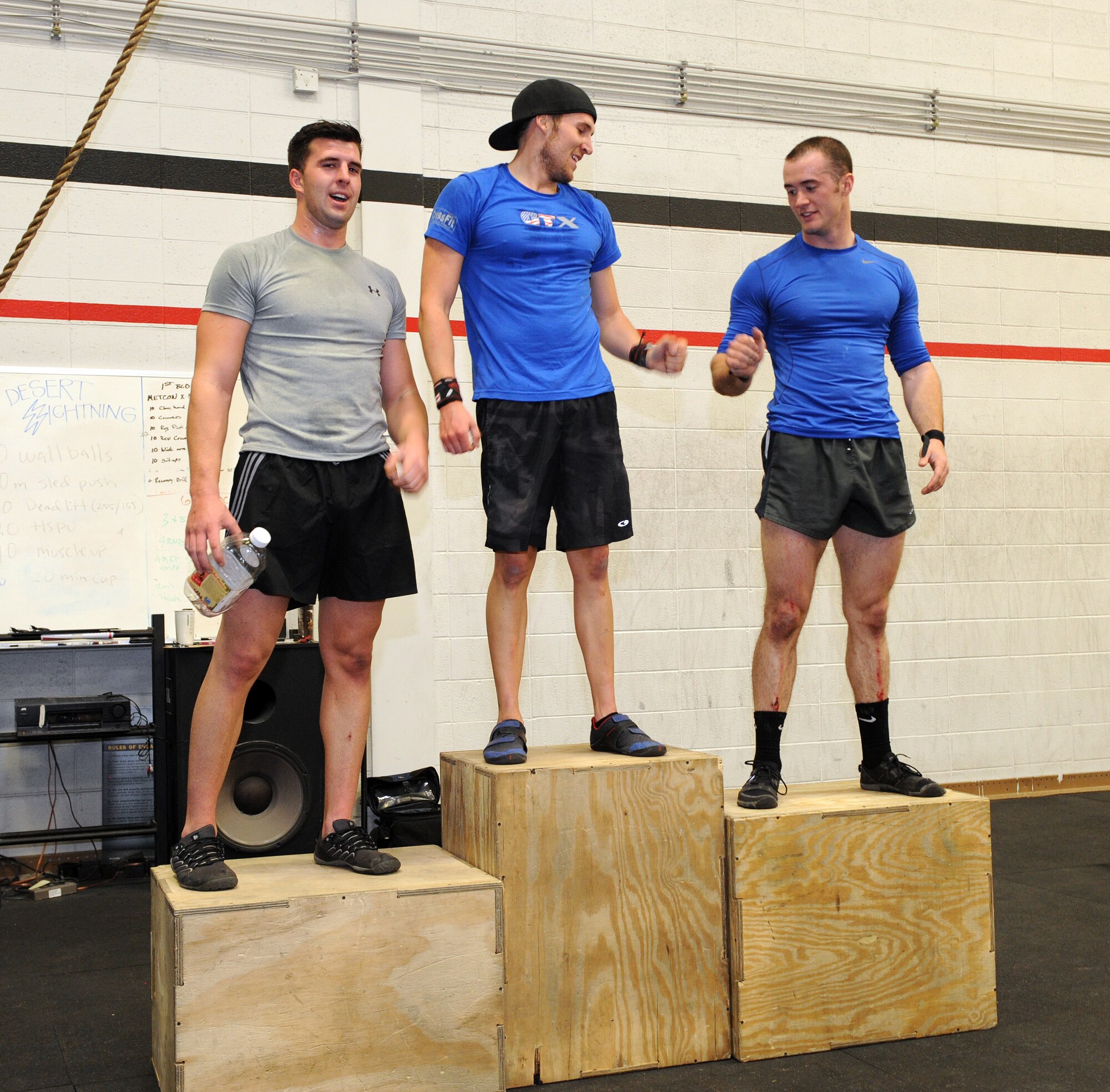 U.S. Air Force Airmen stand on their respective podiums after placing in a quarterly fitness competition at the Haeffner Fitness Center on Davis-Monthan Air Force Base, Ariz. Jan. 17, 2014. Airman 1st Class Cody Elzey (center) came in 1st place, Airman 1st Class Andrew Swan (right) in 2nd and Airman 1st Class Blaine Ward (left) in 3rd. (U.S. Air Force photo by Airman 1st Class Chris Drzazgowski/Released.