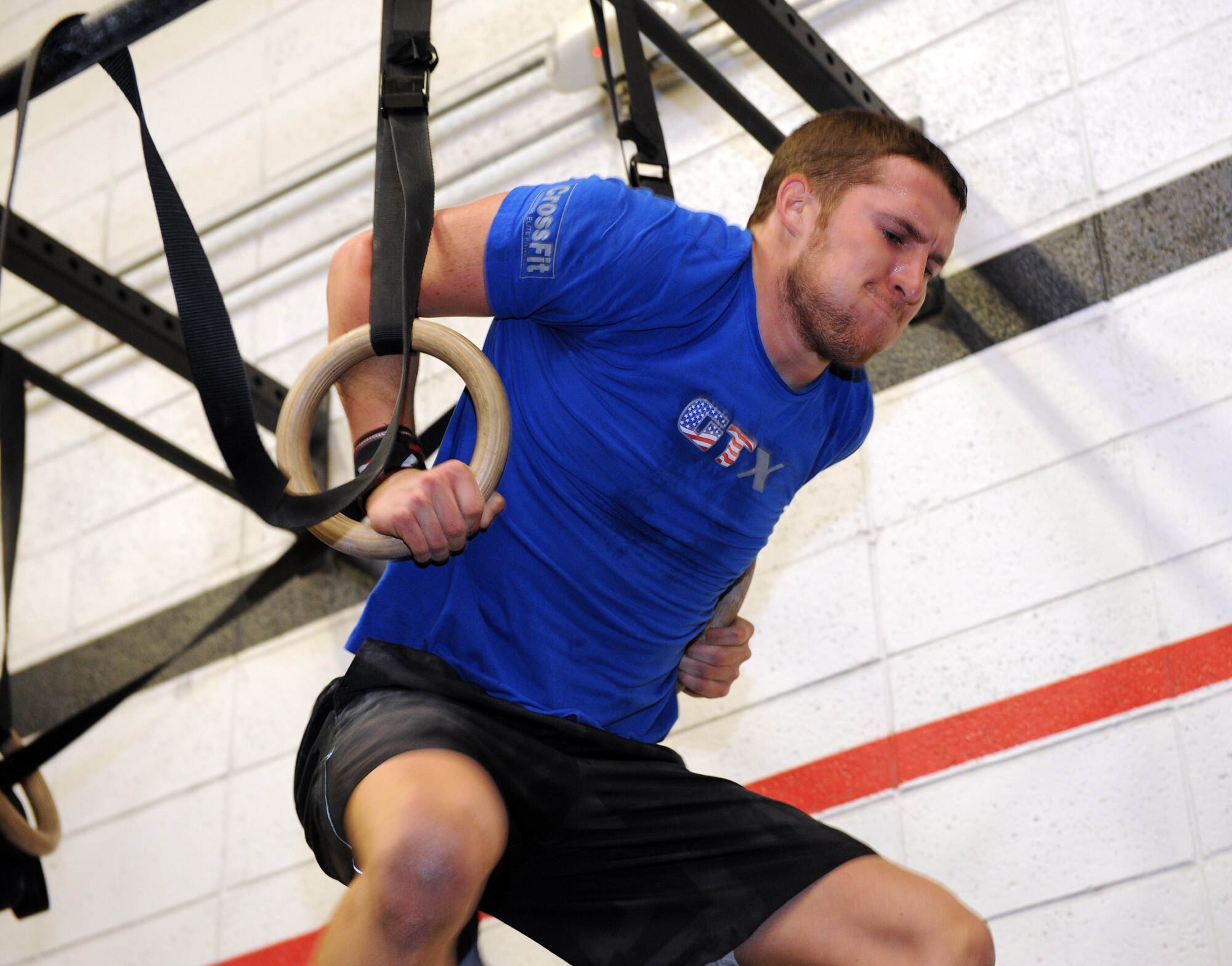 U.S. Air Force Airman 1st Class Cody Elzey, 25th Operational Weather Squadron forecaster, performs a muscle-up during a quarterly fitness competition at Haeffner Fitness Center on Davis-Monthan Air Force Base, Ariz. Jan. 17, 2014. The competition involved many different exercises like deadlifts, handstand push-ups and kettlebell swings. (U.S. Air Force photo by Airman 1st Class Chris Drzazgowski/Released)