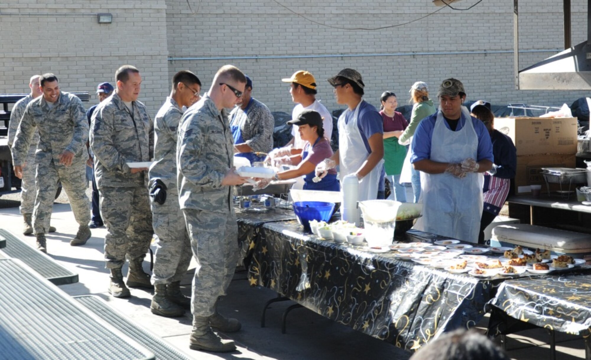 Airmen line up for lunch Jan. 9 at the chapel-sponsored Flightline Feast at the 308th Aircraft Maintenance Unit pavilion. The feast is open to all Airmen at Luke. (U.S. Air Force photo/Staff Sgt. Luther Mitchell Jr.)