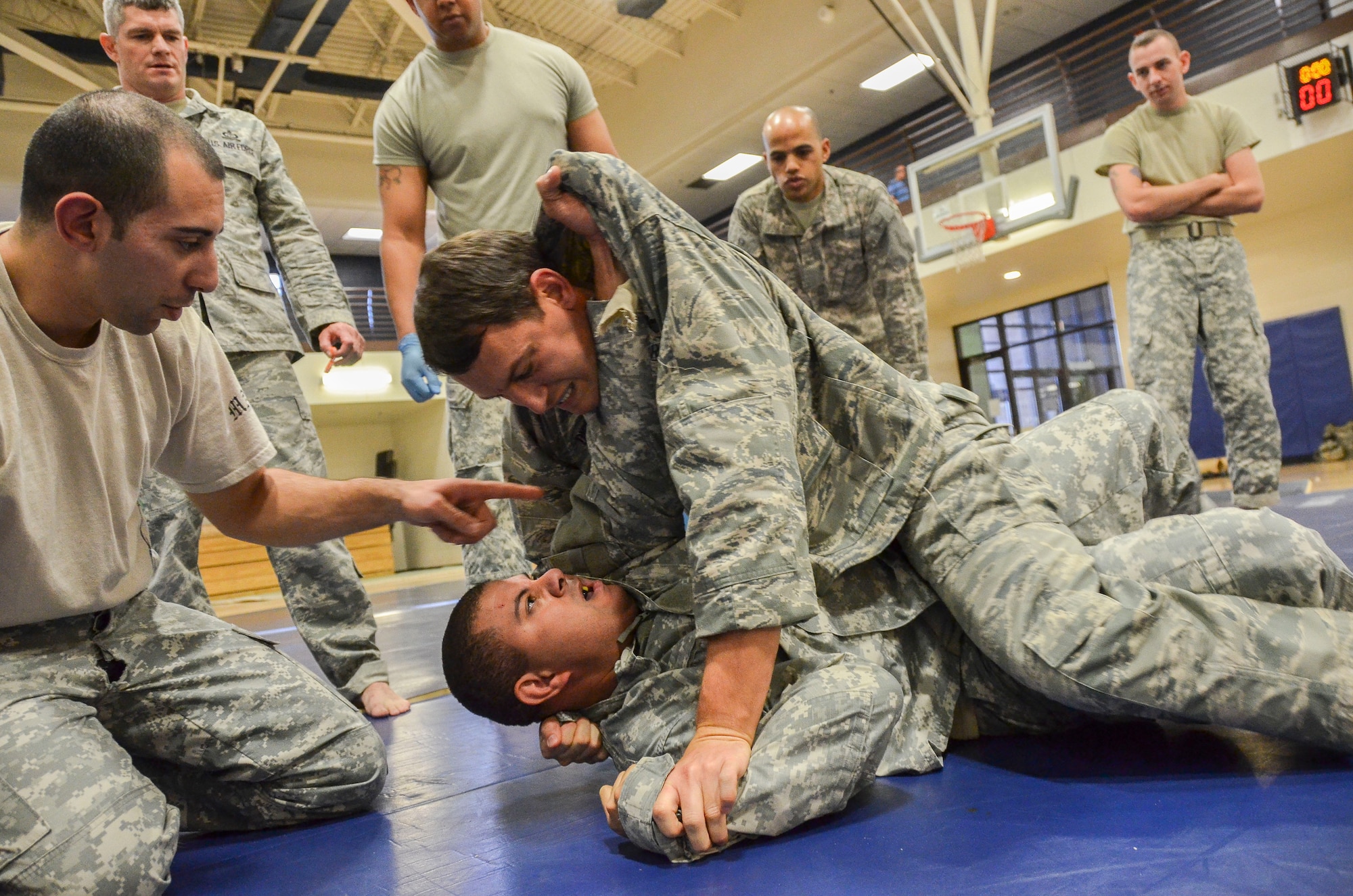 Capt. Brian Dicks, 55th Rescue Squadron, attempts to gain a position of dominance with Maj. Ernah Rodriguez, 1st Battlefield Coordination Detachment, during the Modern Army Combatives Program (MACP) Basic Combatives Course Level 1 at Davis-Monthan Air Force Base, Ariz., Jan. 16, 2014. The 40- hour course focuses on the three phases of basic fighting strategy; close the distance, gain the dominate position, and how to finish the fight. (U.S. Air Force photo by Staff Sgt. Adam Grant/Released)