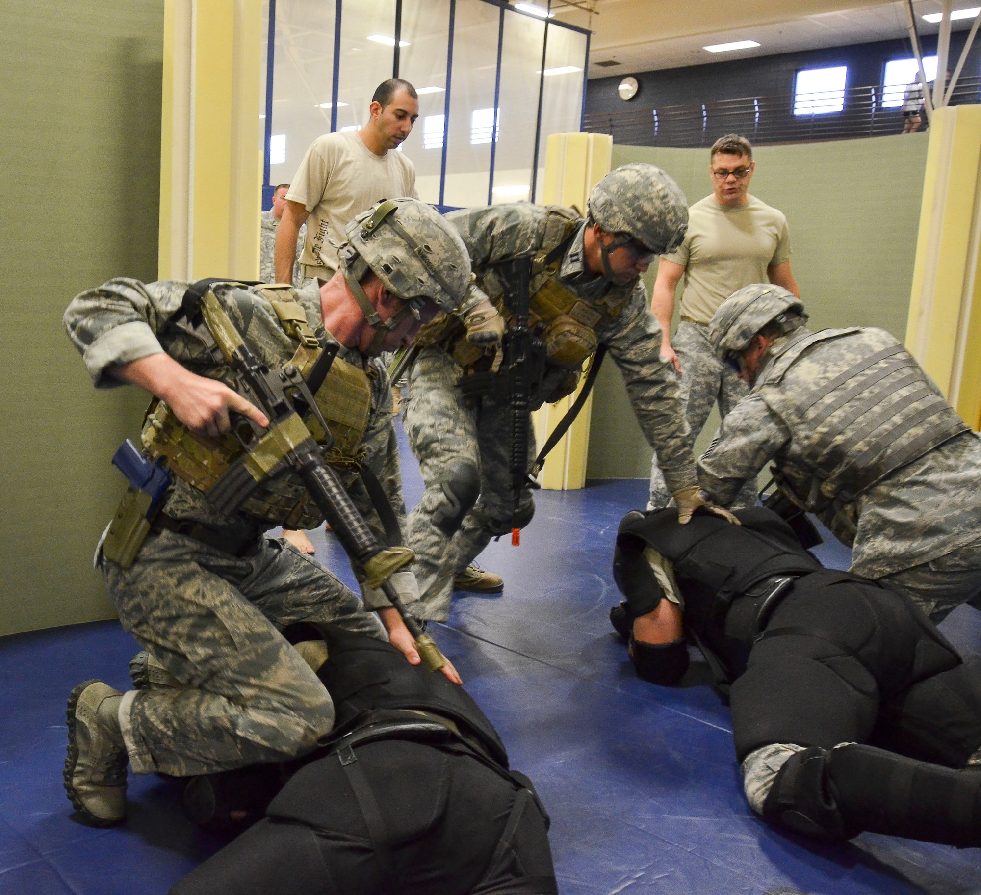 (Left) Maj. Darrell Walton, 45th Fighter Squadron, along with Capt. Brian Dicks, 55th Rescue Squadron, and Senior Master Sgt. Kevin Wendt, 612th Support Squadron, take down two aggressive combatants during the Modern Army Combatives Program (MACP) Basic Combatives Course Level at Davis-Monthan Air Force Base, Ariz., 1 Jan. 16, 2014. The 40-hour course focuses on the three phases of basic fighting strategy; close the distance, gain the dominate position, and how to finish the fight. (U.S. Air Force photo by Staff Sgt. Adam Grant/Released)