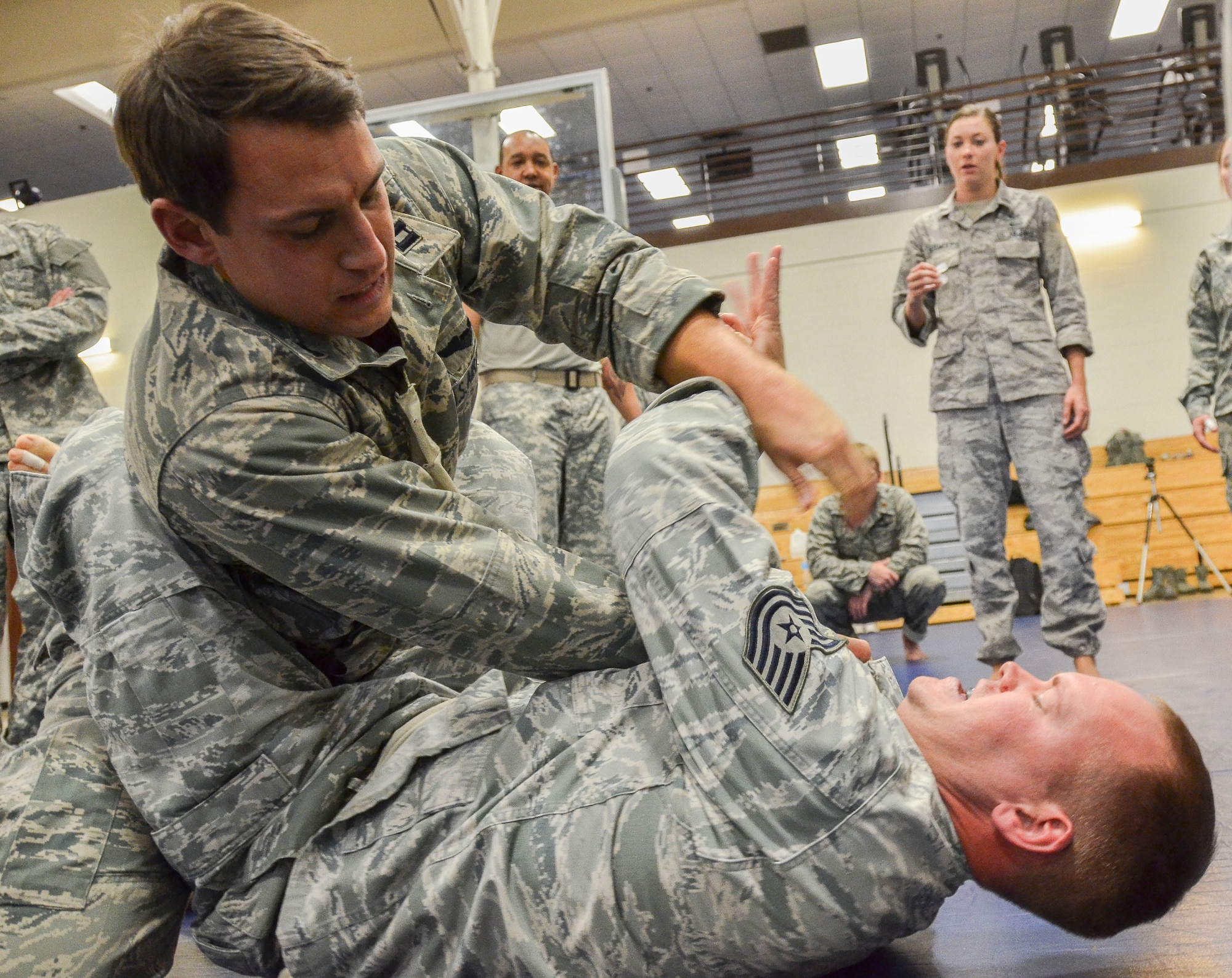Capt. Brian Dicks, 55th Rescue Squadron, attempts a submission on Tech Sgt. Joshua Holliday, 612th Air and Space Operations Center, during the Modern Army Combatives Program (MACP) Basic Combatives Course Level 1 at Davis-Monthan Air Force Base, Ariz., Jan. 16, 2014. The 40-hour course focuses on the three phases of basic fighting strategy; close the distance, gain the dominate position, and how to finish the fight. (U.S. Air Force photo by Staff Sgt. Adam Grant/Released)