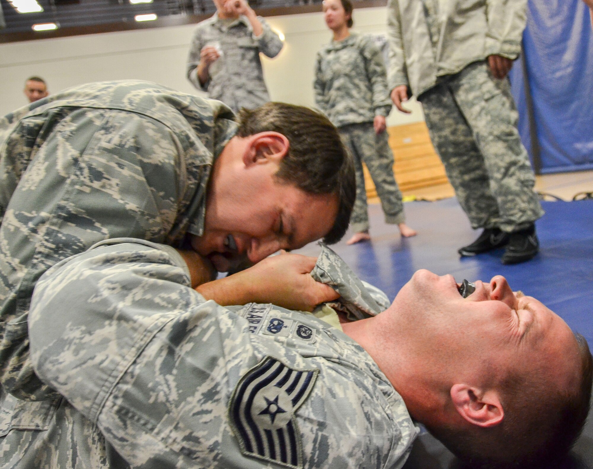 Capt. Brian Dicks, 55th Rescue Squadron, attempts to gain a dominant position on Tech Sgt. Joshua Holliday, 612th Air and Space Operations Center, during the Modern Army Combatives Program (MACP) Basic Combatives Course Level 1 at Davis-Monthan Air Force Base, Ariz., Jan. 16, 2014. The 40-hour course focuses on the three phases of basic fighting strategy; close the distance, gain the dominate position, and how to finish the fight. (U.S. Air Force photo by Staff Sgt. Adam Grant/Released)