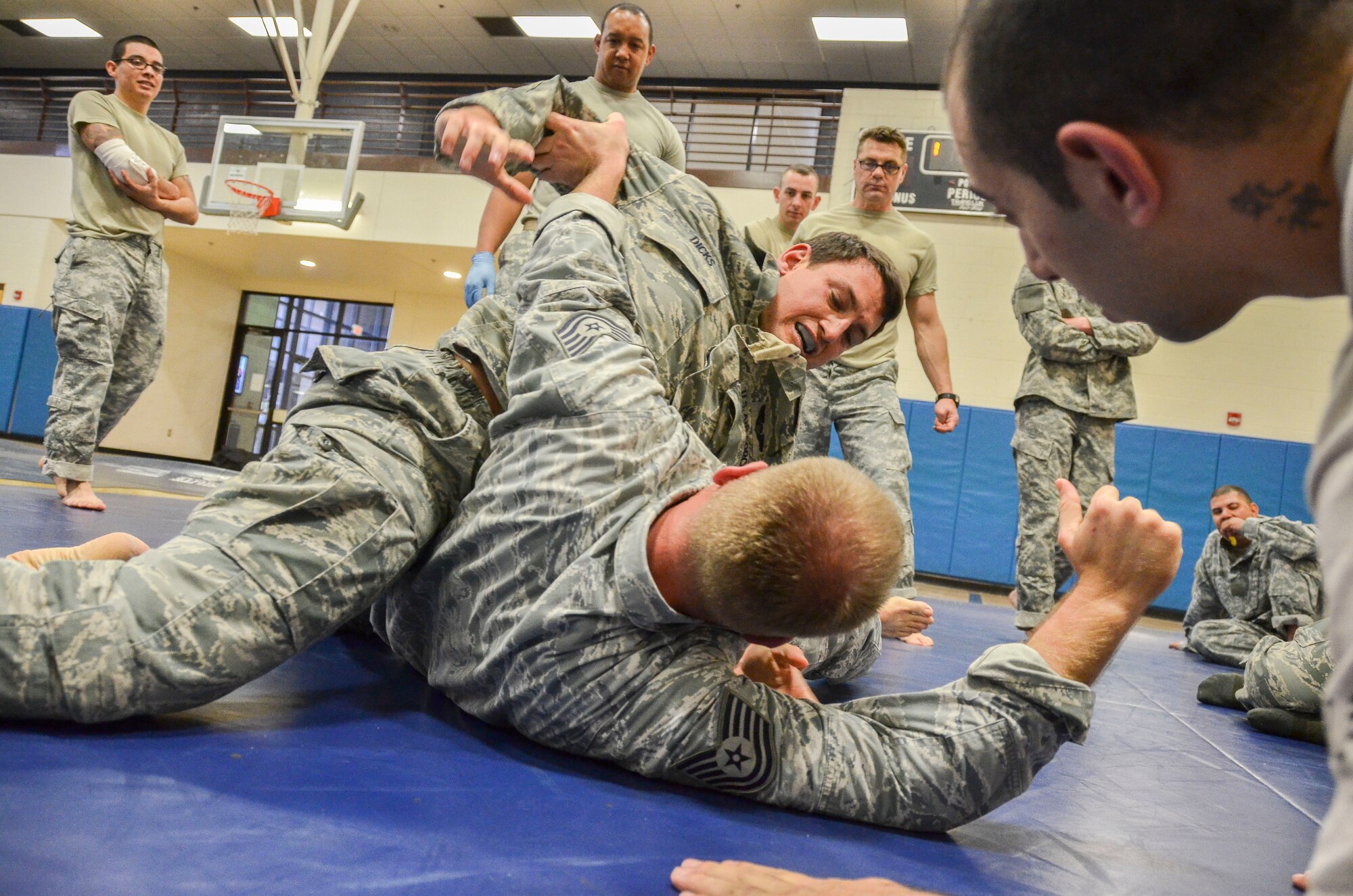 Capt. Brian Dicks, 55th Rescue Squadron, attempts to gain a dominant position on Tech Sgt. Joshua Holliday, 612th Air and Space Operations Center, during the Modern Army Combatives Program (MACP) Basic Combatives Course Level 1 at Davis-Monthan Air Force Base, Ariz., Jan. 16, 2014. The 40-hour course focuses on the three phases of basic fighting strategy; close the distance, gain the dominate position, and how to finish the fight. (U.S. Air Force photo by Staff Sgt. Adam Grant/Released)