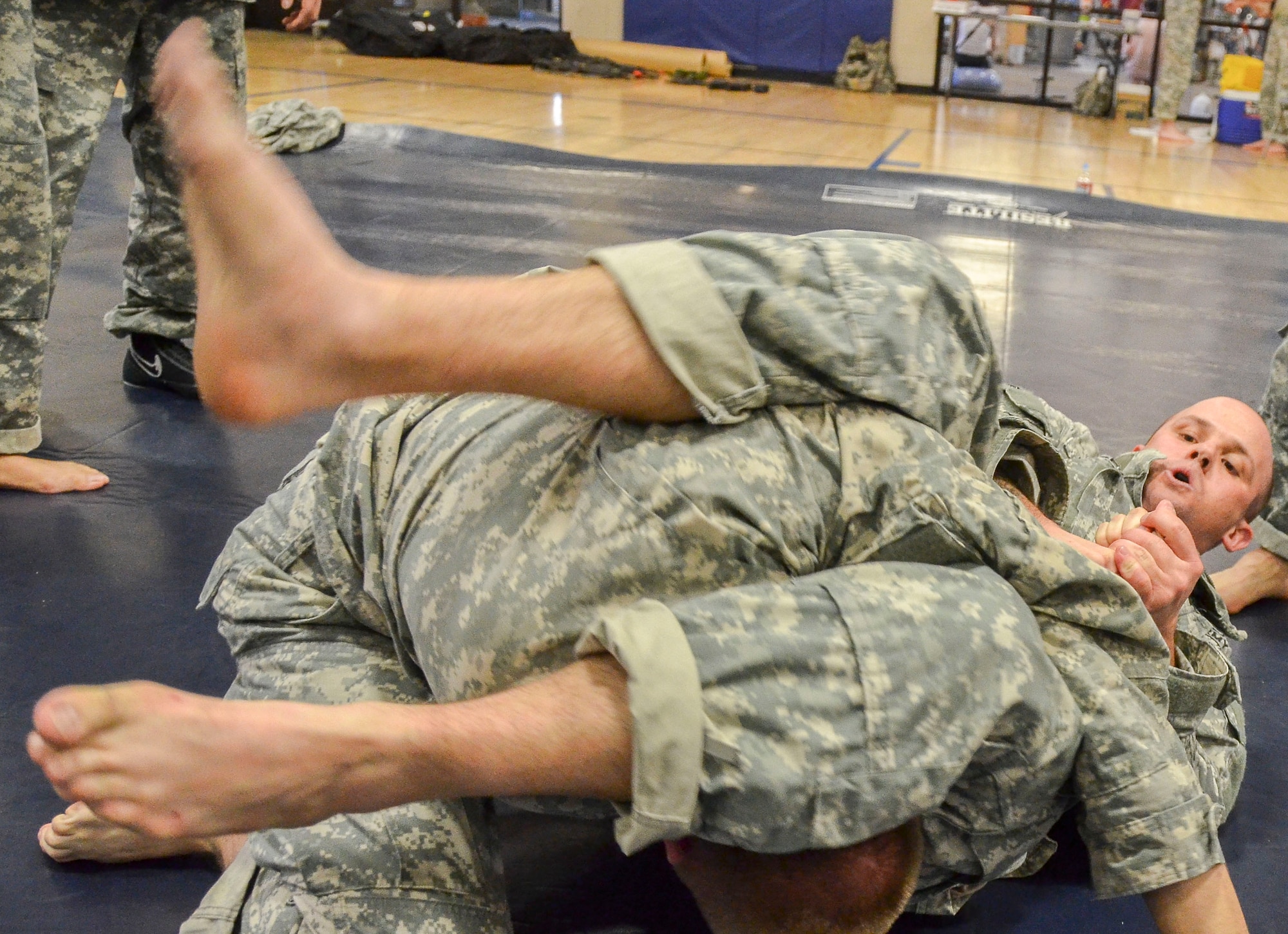 Sgt. 1st Class Logan Reiser, 1st Battlefield Coordination Detachment, attempts a submission on Private 1st Class Acea Hindbaugh, 1st Battlefield Coordination Detachment, during the Modern Army Combatives Program (MACP) Basic Combatives Course Level 1 at Davis-Monthan Air Force Base, Ariz., Jan. 16, 2014. The 40-hour course focuses on the three phases of basic fighting strategy; close the distance, gain the dominate position, and how to finish the fight. (U.S. Air Force photo by Staff Sgt. Adam Grant/Released)