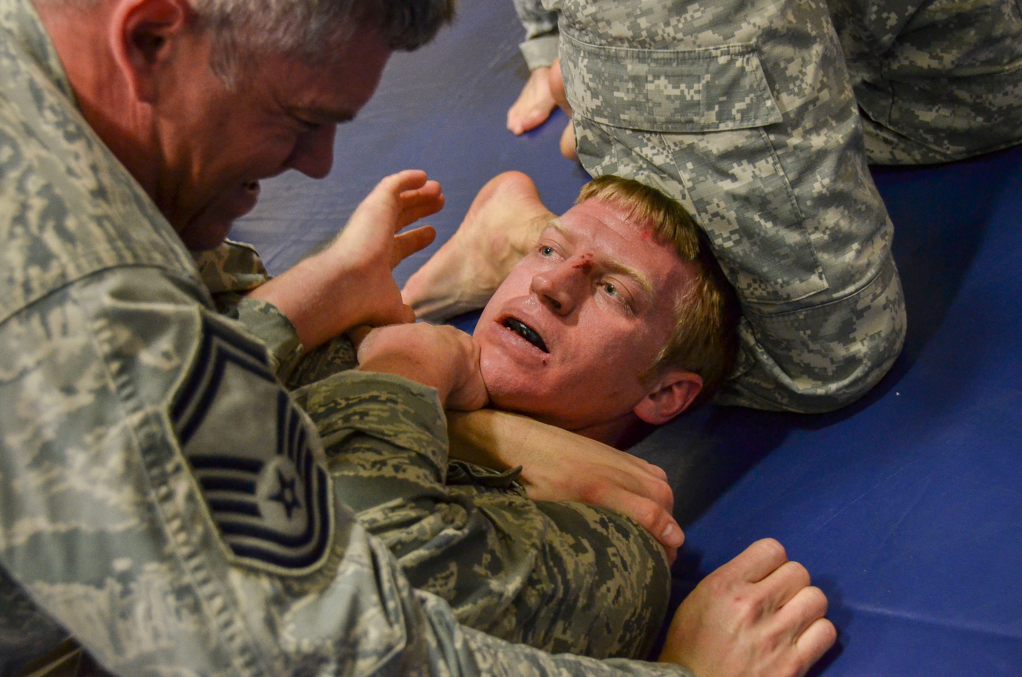 Senior Master Sgt. Kevin Wendt, 612th Support Squadron, attempts to subdue Maj. Darrell Walton, 45th Fighter Squadron, during the last man standing drill portion of the Modern Army Combatives Program (MACP) Basic Combatives Course Level 1 at Davis-Monthan Air Force Base, Ariz., Jan. 16, 2014. The 40- hour course focuses on the three phases of basic fighting strategy; close the distance, gain the dominate position, and how to finish the fight. (U.S. Air Force photo by Staff Sgt. Adam Grant/Released)