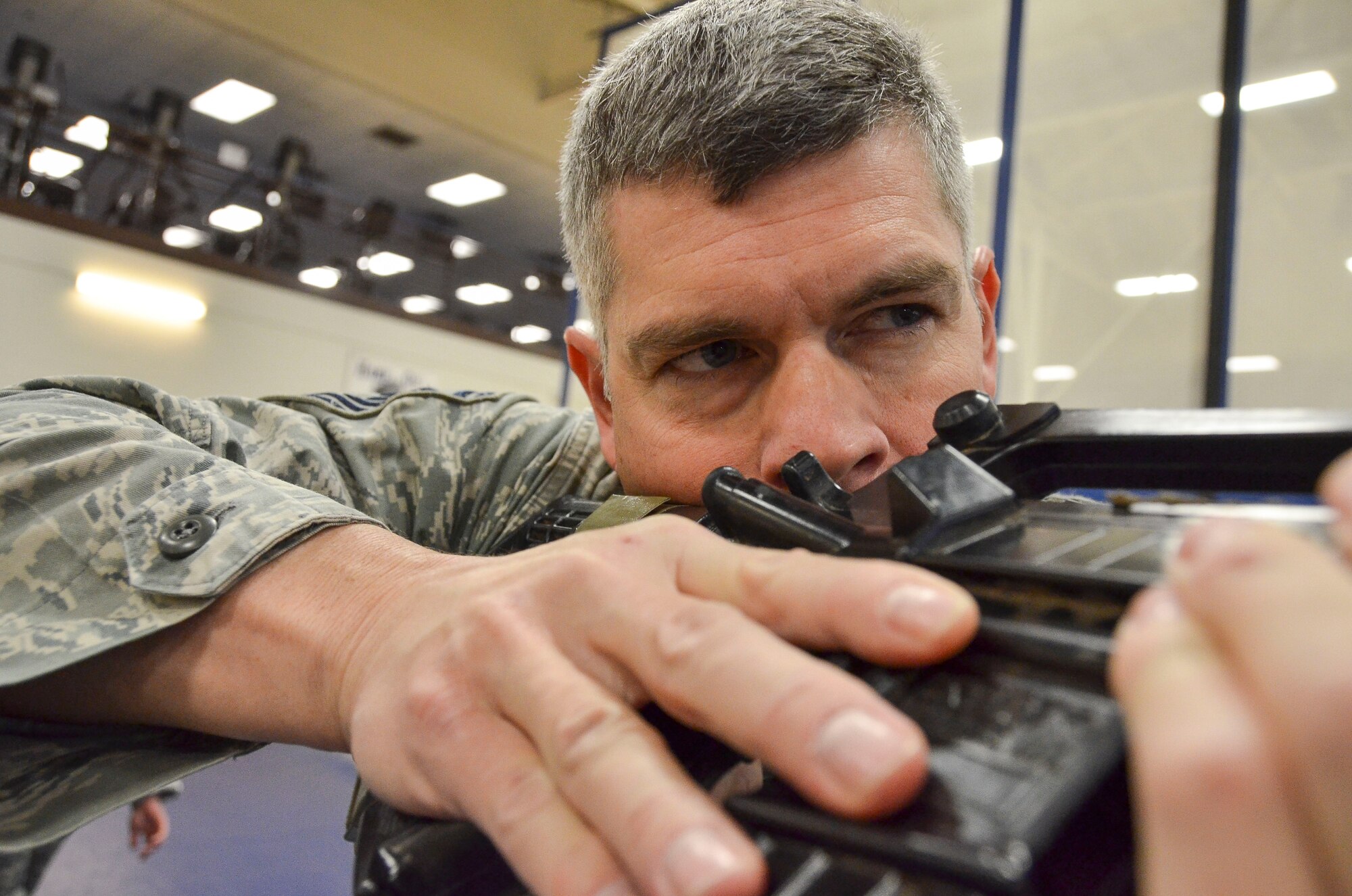 Senior Master Sgt. Kevin Wendt, 612th Support Squadron, practices looking down the sight of his weapon before going through the room clearing portion of the Modern Army Combatives Program (MACP) Basic Combatives Course Level 1 at Davis-Monthan Air Force Base, Ariz., Jan. 16, 2014.The 40- hour course focuses on the three phases of basic fighting strategy; close the distance, gain the dominate position, and how to finish the fight. (U.S. Air Force photo by Staff Sgt. Adam Grant/Released)