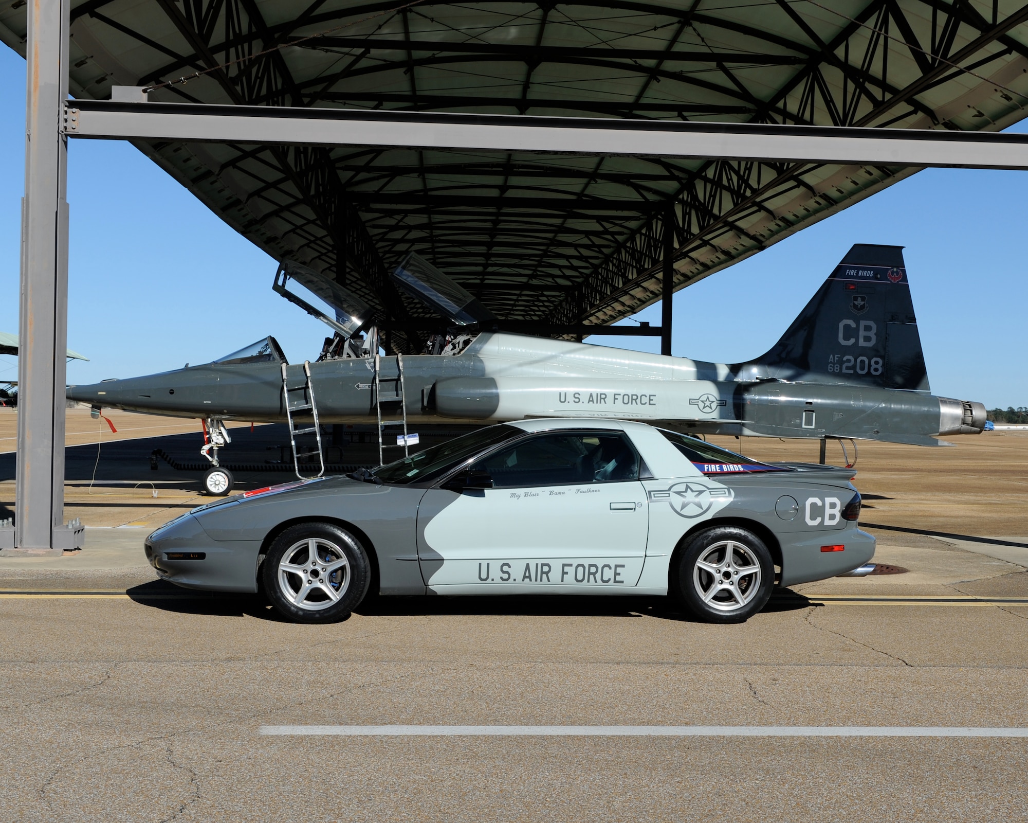 A 1994 Pontiac Firebird sits next to a T-38 Talon at Columbus Air Force Base, Miss. Jan. 14, 2014. Multiple personnel and several Columbus community members contributed their time and resources to create this squadron vehicle which serves as a tribute to Maj. Blair Faulkner, U.S. Air Force Reserve instructor pilot, who died April 23, 2008 in a T-38 crash along with his student 2nd Lt. Matthew Emmons. (U.S. Air Force Photo/Elizabeth Owens)