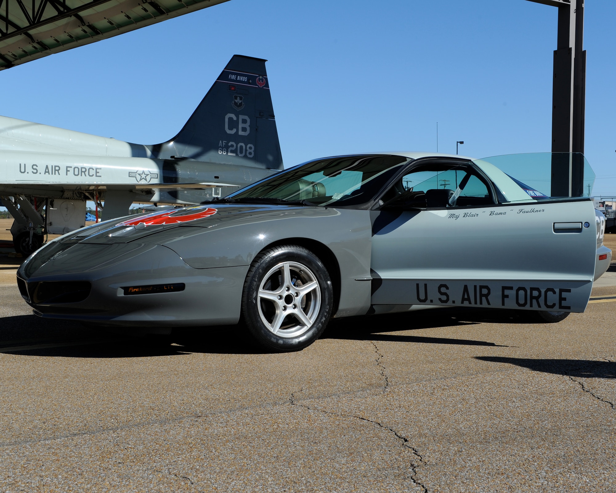 A 1994 Pontiac Firebird sits next to a T-38 Talon at Columbus Air Force Base, Miss. Jan. 14, 2014. The car was made as tribute to Maj. Blair Faulkner, U.S. Air Force Reserve instructor pilot, who died April 23, 2008 in a T-38 crash. After his death, Rachel Faulkner, his widow, donated the car to honor one of his dreams of having a car for people on base that needed temporary transportation. (U.S. Air Force Photo/Elizabeth Owens)