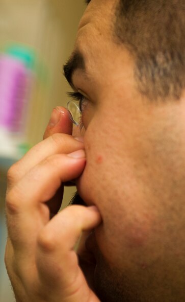 Senior Airman Ted Tanaka, 5th Maintenance Squadron crew chief, puts in new contacts at Minot Air Force Base’s optometry office, Jan. 14, 2014. The office’s new doctor arrived in August, and the office has since returned to full-service eye care. (U.S. Air Force photo/Airman 1st Class Apryl Hall)