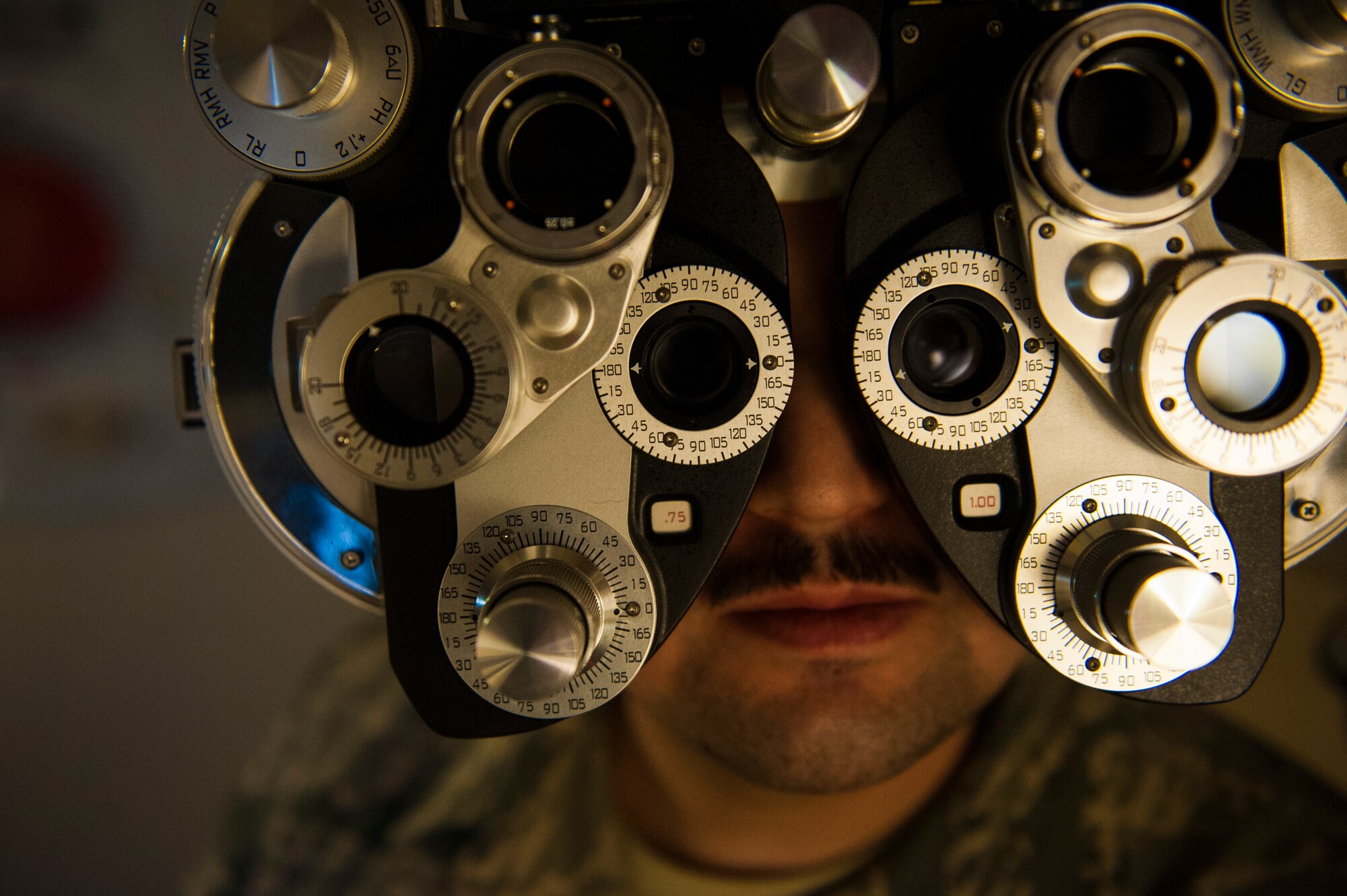 Senior Airman Ted Tanaka, 5th Maintenance Squadron crew chief, looks through lenses at Minot Air Force Base’s optometry office, Jan. 14, 2014. Although the base was without an optometrist through the summer of 2013, Capt. Eric Noll, 5th Medical Operations Squadron optometrist, took over in August and the office is back to giving full-service eye care. (U.S. Air Force photo/Airman 1st Class Apryl Hall)