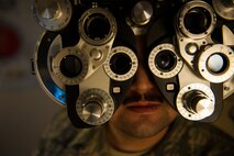 Senior Airman Ted Tanaka, 5th Maintenance Squadron crew chief, looks through lenses at Minot Air Force Base’s optometry office, Jan. 14, 2014. Although the base was without an optometrist through the summer of 2013, Capt. Eric Noll, 5th Medical Operations Squadron optometrist, took over in August and the office is back to giving full-service eye care. (U.S. Air Force photo/Airman 1st Class Apryl Hall)